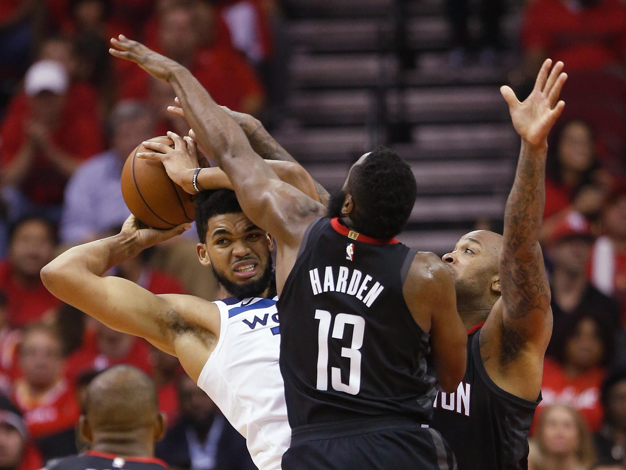 Minnesota Timberwolves center Karl-Anthony Towns is cornered by Rockets guard James Harden and forward PJ Tucker during the first half of Game 5