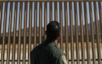 A U.S. Border Patrol agent looks at one of border wall prototypes Thursday, June 28, 2018, in San Diego. (AP Photo/Jae C. Hong, File) ORG XMIT: MIN201