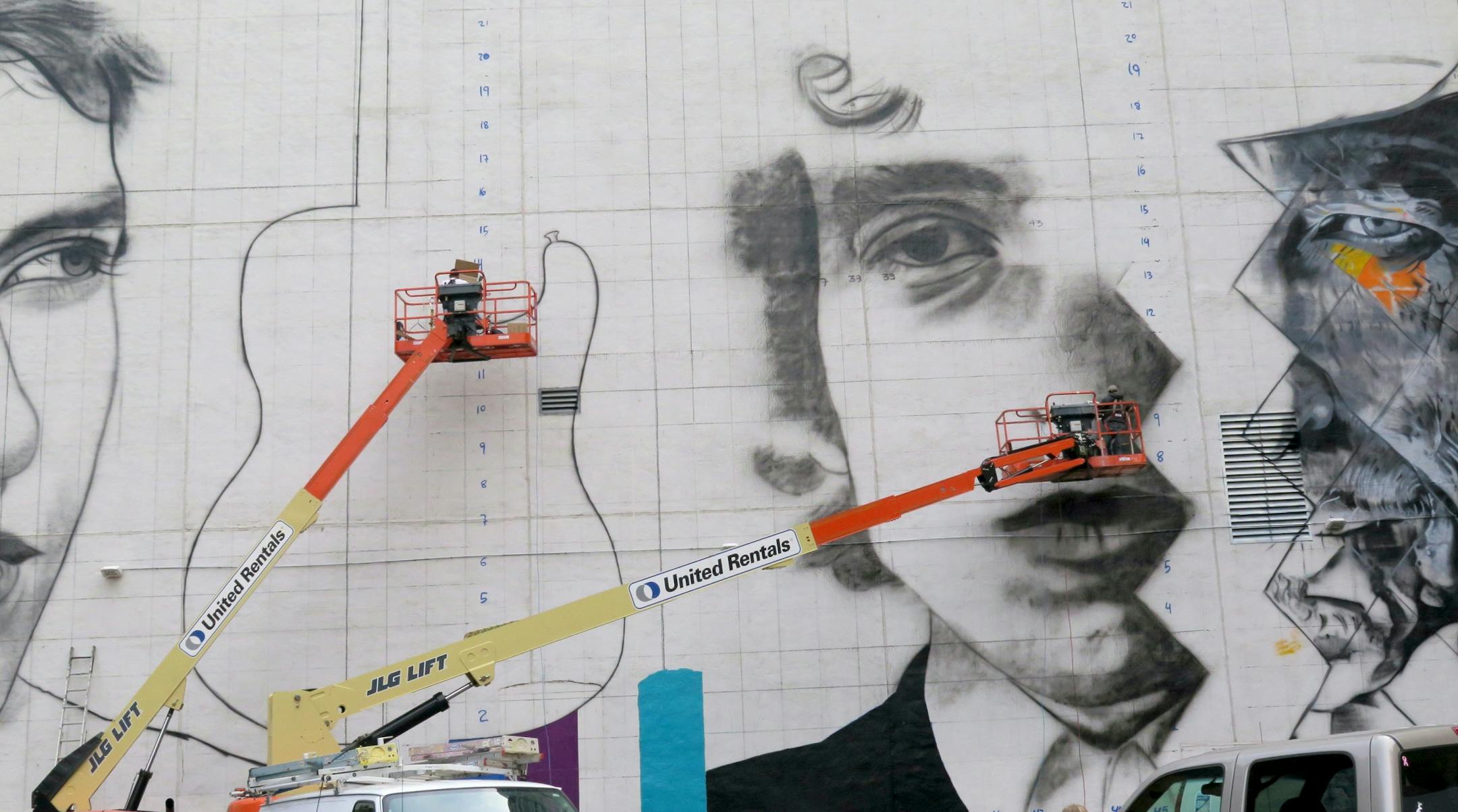 The work has begun and will will continue over the next two weeks as Brazilian artist Eduardo Kobra and his team of five artists -- three from Brazil and two from Minnesota -- attack the blank wall using boom lifts and air compressors to create a three-paneled image of musician Bob Dylan.