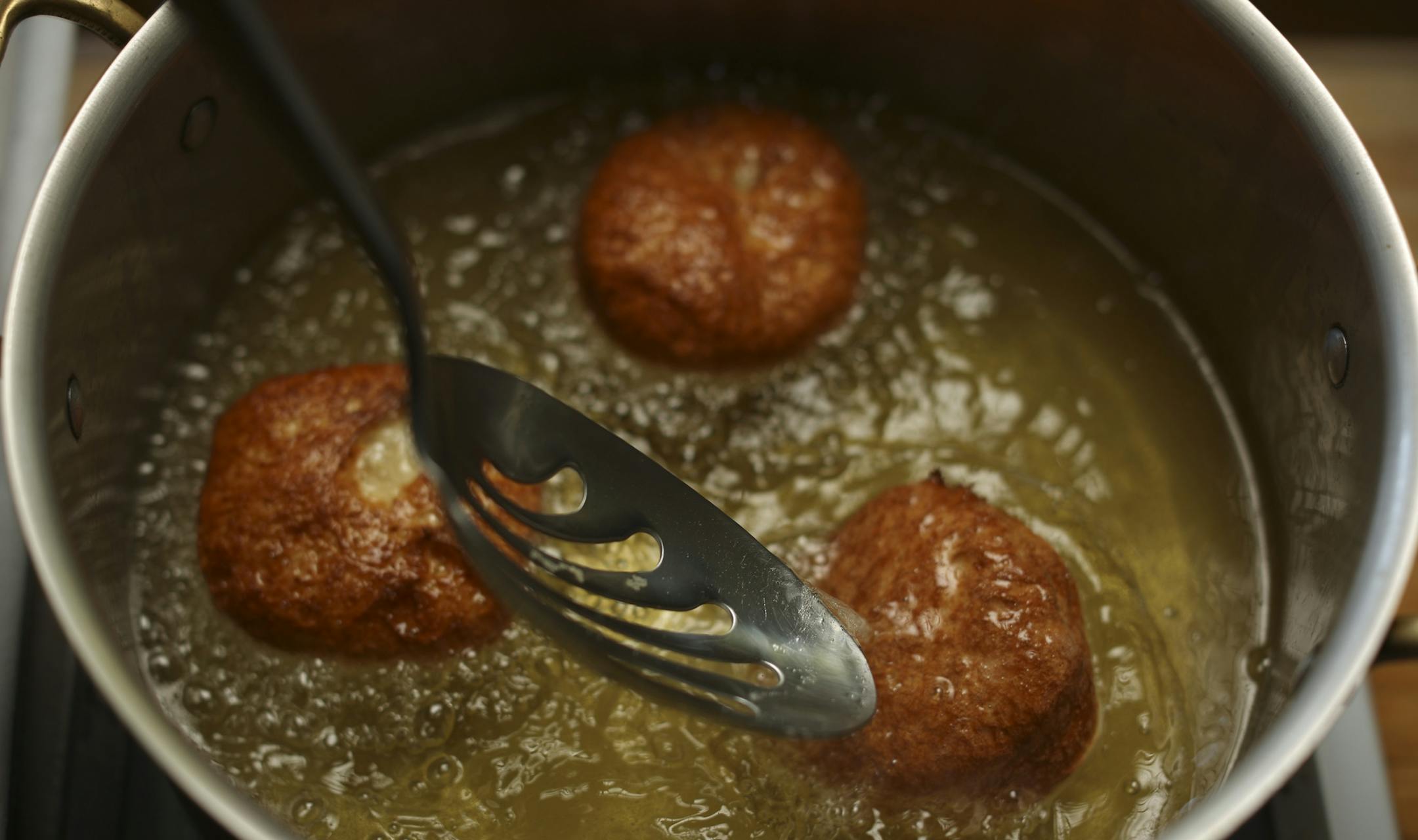 Baking Central takes on krofi, the light and lemony fried pastry from Slovenia. Krofi preparation in Kim Ode's Edina kitchen on Thursday afternoon, October 10, 2013. Turning the frying krofi in the hot oil. ] JEFF WHEELER ‚Ä¢ jeff.wheeler@startribune.com