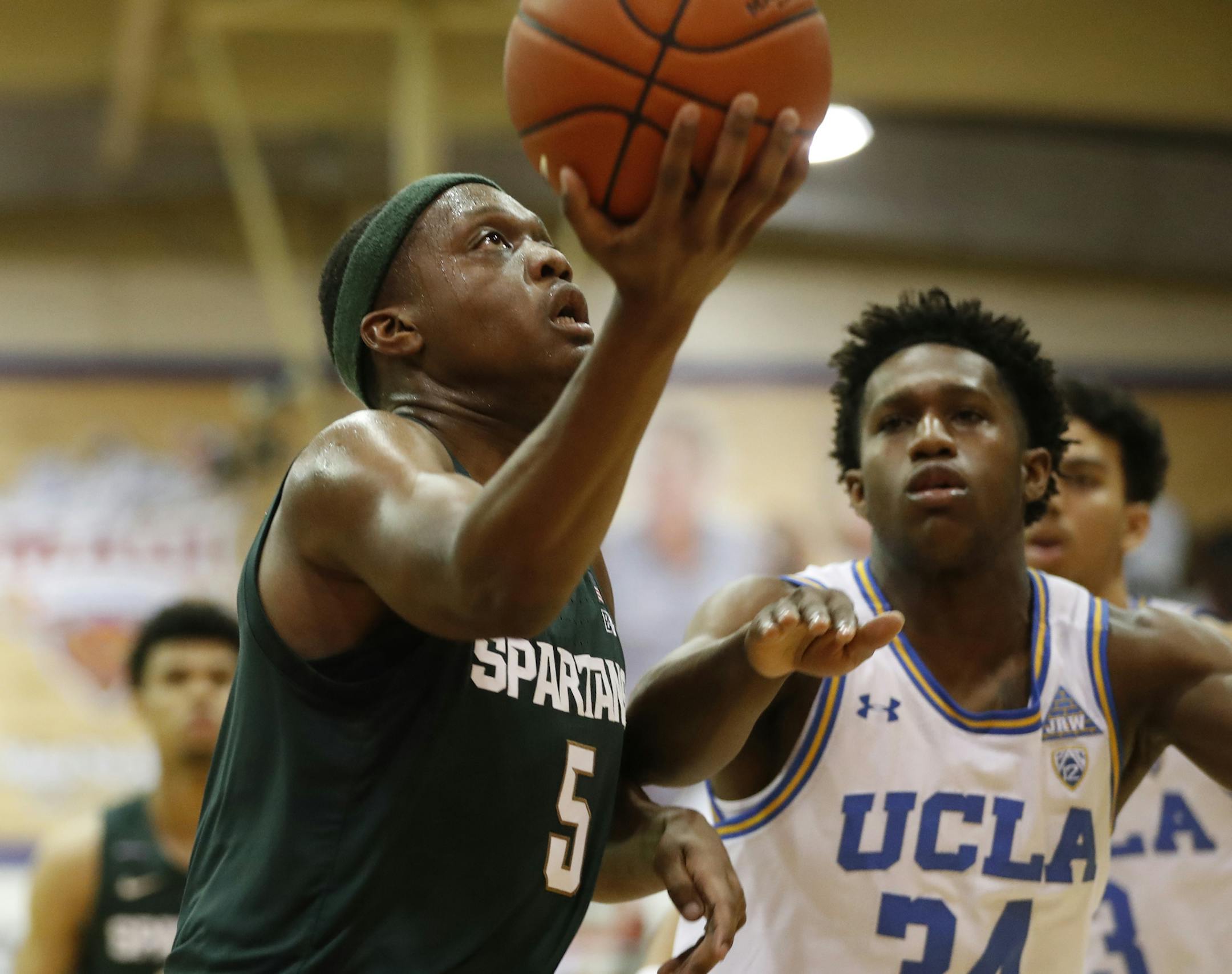 Michigan State guard Cassius Winston (5) heads for the basket ahead of UCLA guard David Singleton (34) during the first half of an NCAA college basketball game Wednesday, Nov. 27, 2019, in Lahaina, Hawaii. (AP Photo/Marco Garcia)