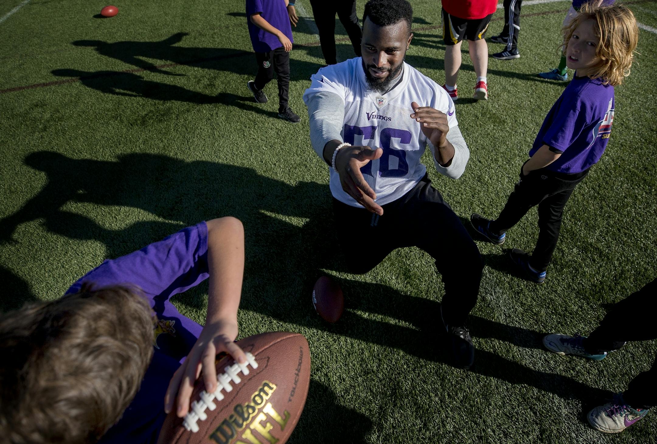 Antwione Williams (55) worked with young athletes during an NFL FLAG event after Minnesota Vikings practice at the London Irish Training Ground.