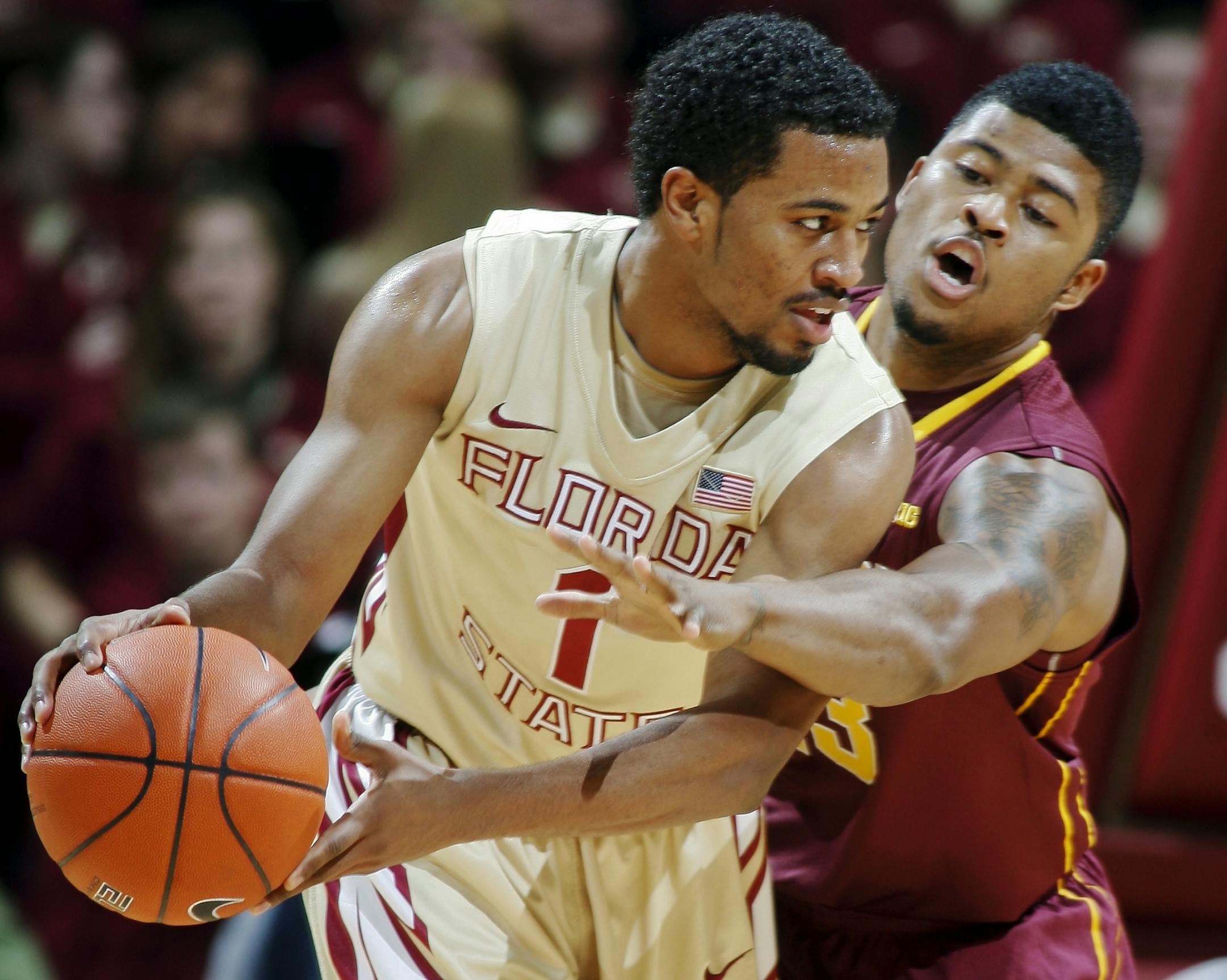 Minnesota guard Maverick Ahanmisi, rear, tries to steal the ball from Florida State guard Devon Bookert (1) in the first half of an NCAA college basketball game, Tuesday, Nov. 27, 2012, in Tallahassee, Fla. Minnesota won 77-68.