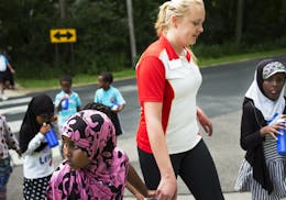 Counselor Crystal Altobelli, holding the hand of Zagal Abdi,7, helped kids cross the street from a nearby park.