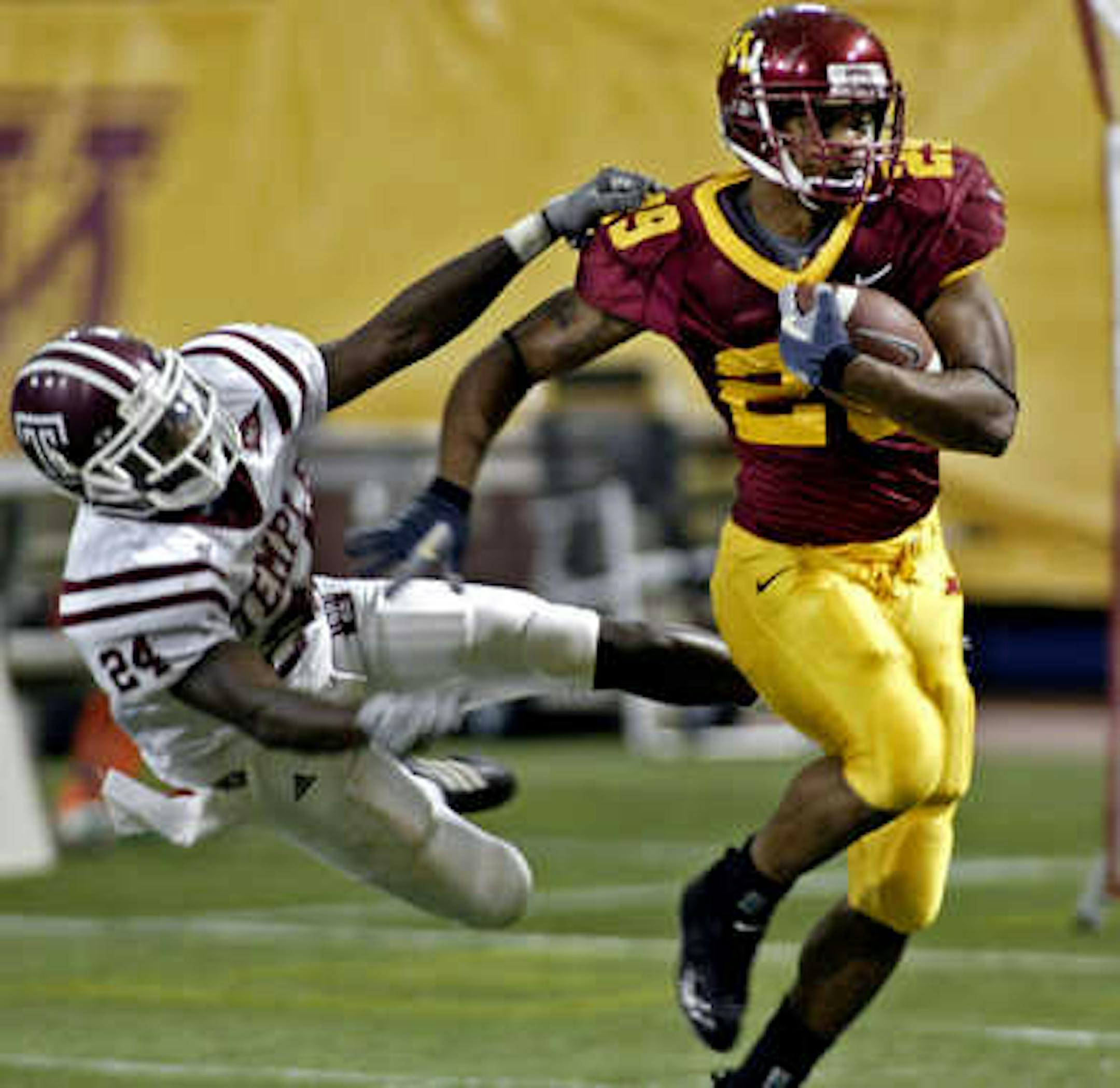Gophers running back Amir Pinnix shakes off the tackle of Temple's Chris Page #24 as he rambles for 30 yards in first-half action Saturday.
