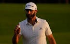 Dustin Johnson holds up his ball on the 18th green after his third round of the Masters golf tournament Saturday, Nov. 14, 2020, in Augusta, Ga. (AP P