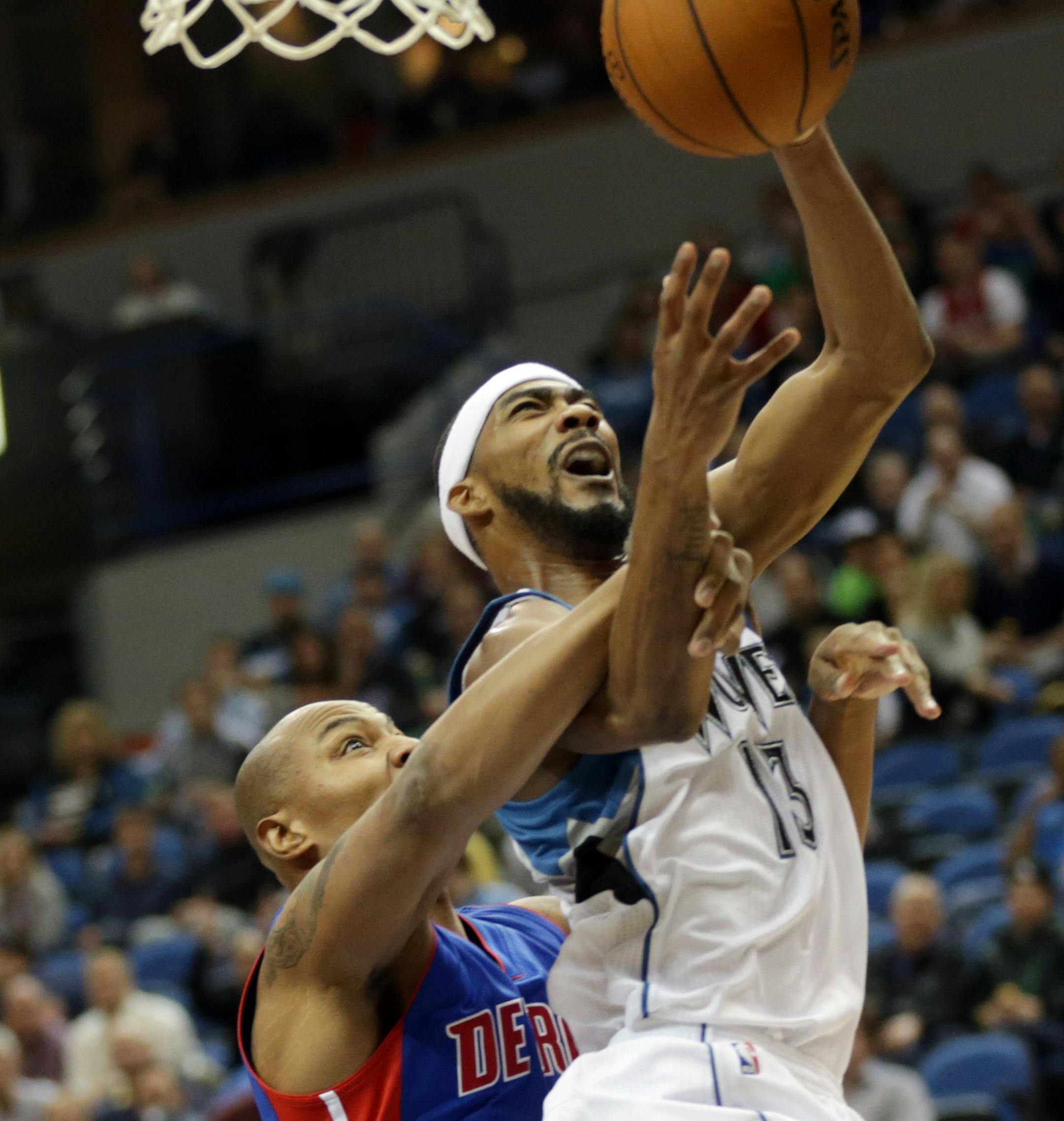 Detroit Pistons' Caron Butler, left, tries to break up a shot by Minnesota Timberwolves' Corey Brewer in the first quarter of an NBA basketball game, Thursday, Oct. 30, 2014, in Minneapolis. (AP Photo/Jim Mone)