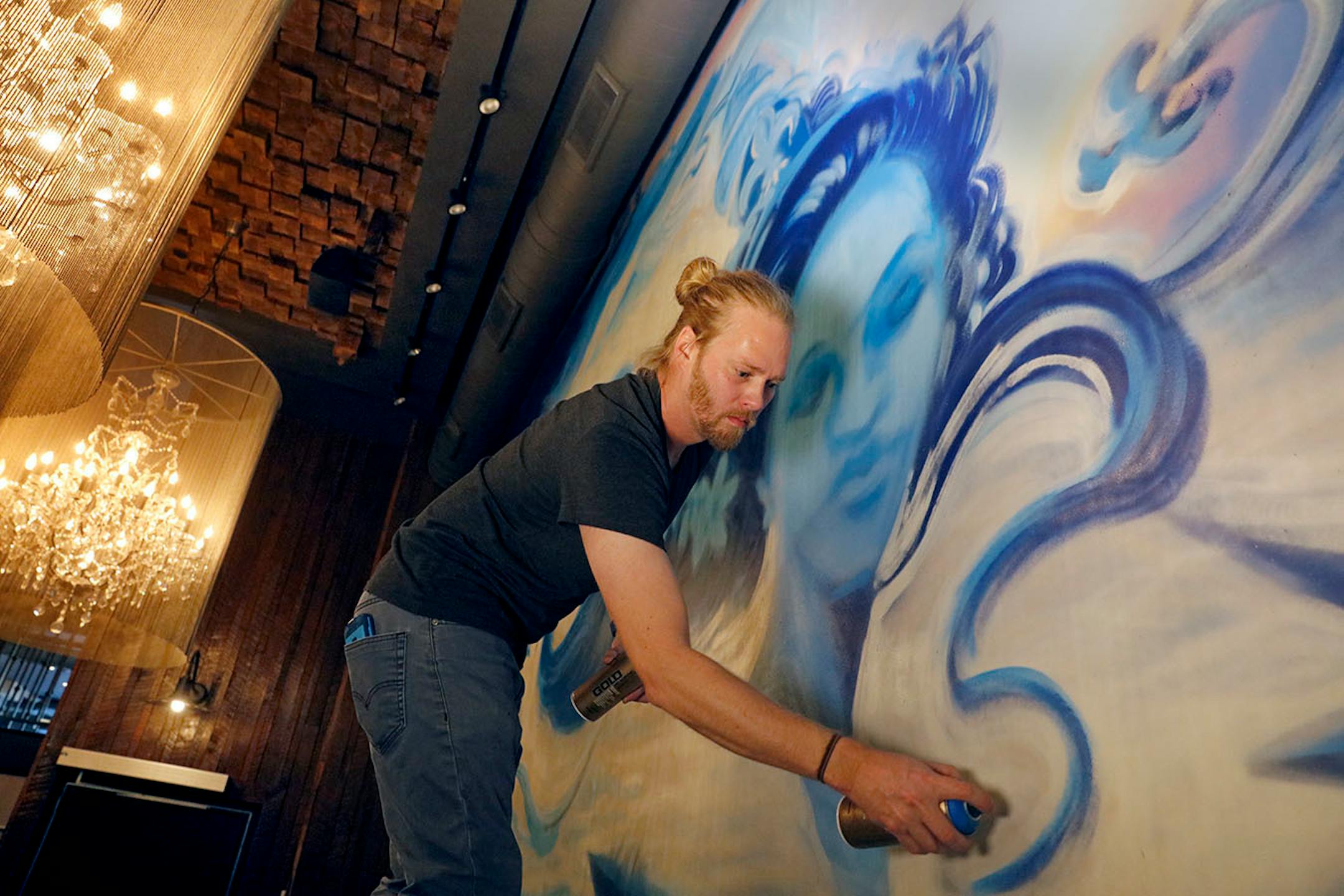 Adam Dennis works on his murals at Coup d'Etat restaurant in Uptown. Dennis' work include Smack Shack and the Pourhouse and is done with chalk and spray paint.