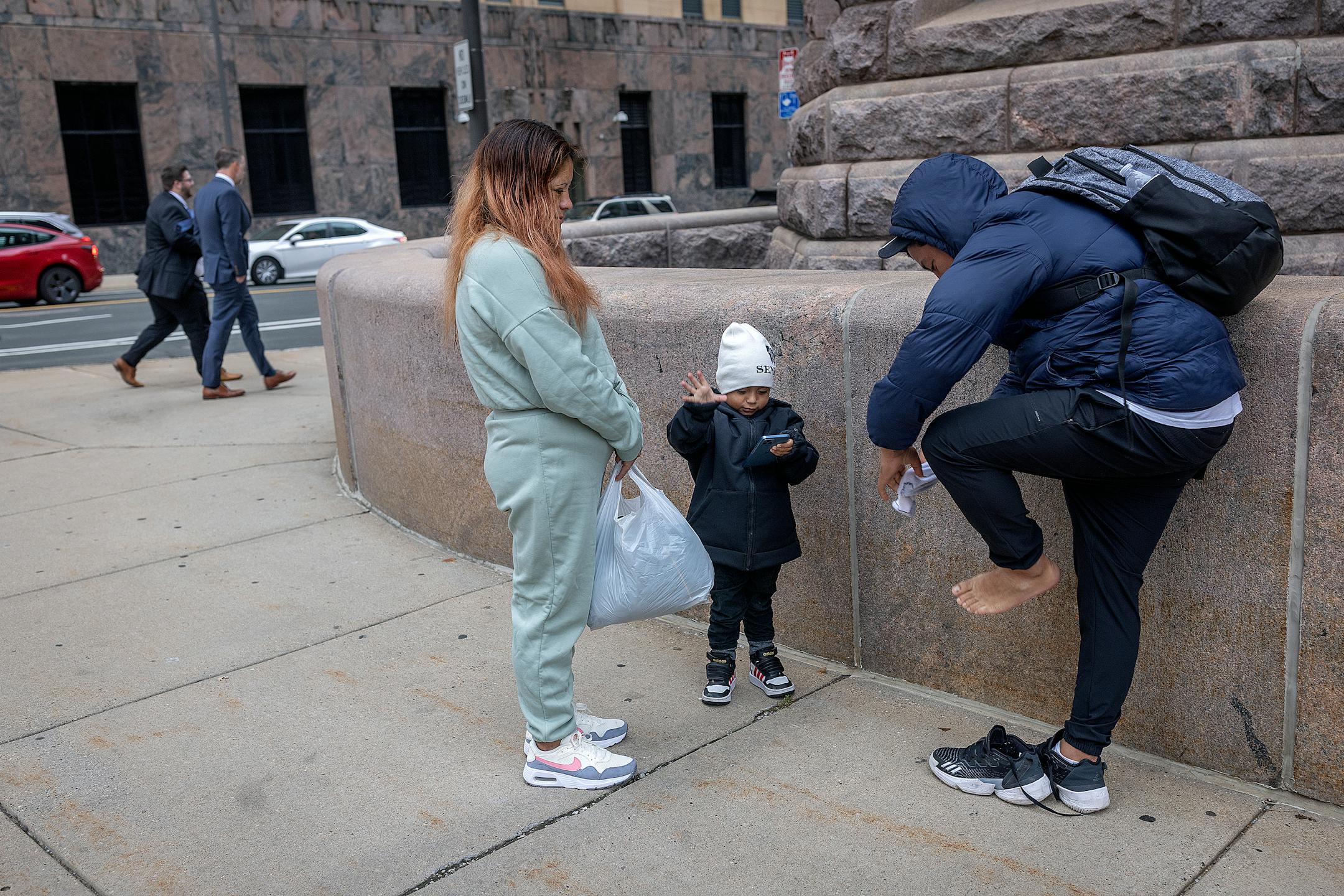Jhon Requelme puts on socks that his partner Sara brought him during a visit near their family shelter, on Wednesday, Oct. 25 "No tengo calecetines y tengo frio," said Jhon. ("I don't have socks and I'm cold.")