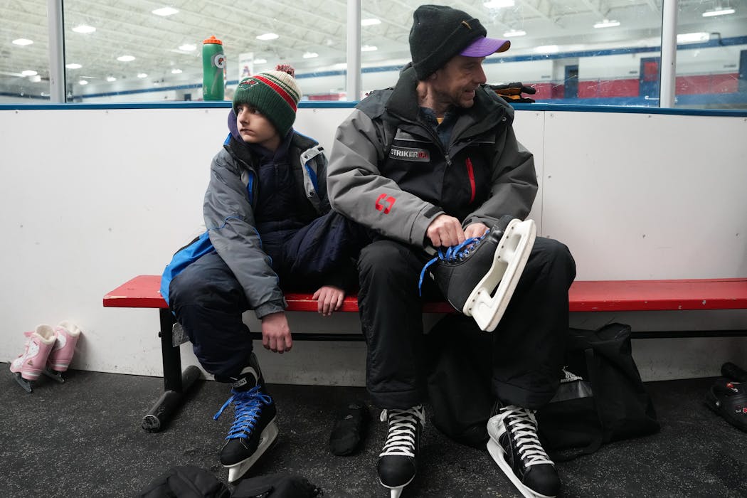 Jake Henningsgaard helped lace up the skates on his son Adrian before the two participate in a skating lesson at the ice arena in New Hope.
