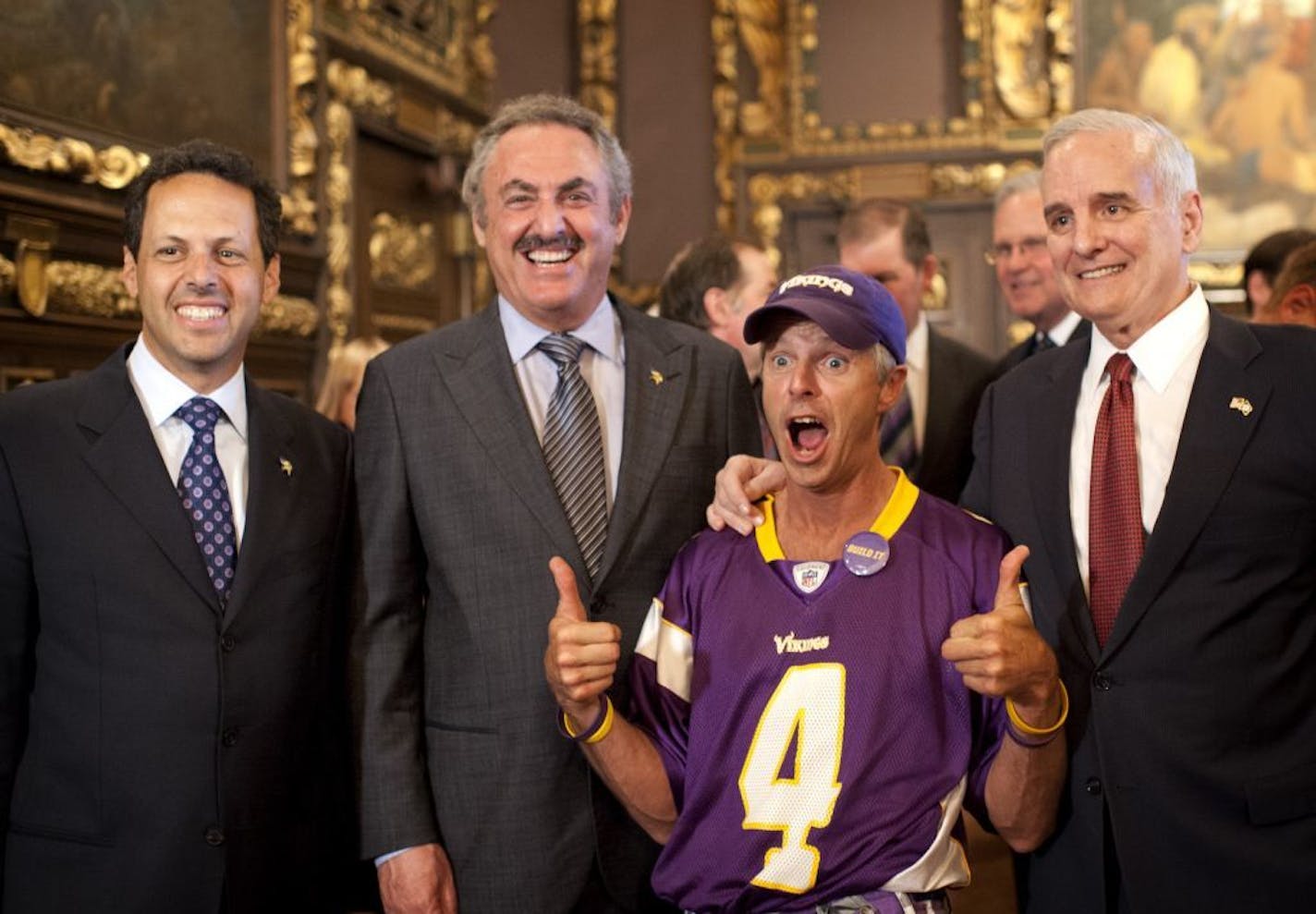 Vikings fan Larry Spooner, who attended countless legislative hearings on the stadium posed with Governor Dayton and Mark and Zygi Wilf at a private reception before the bill signing Monday May 14, 2012.