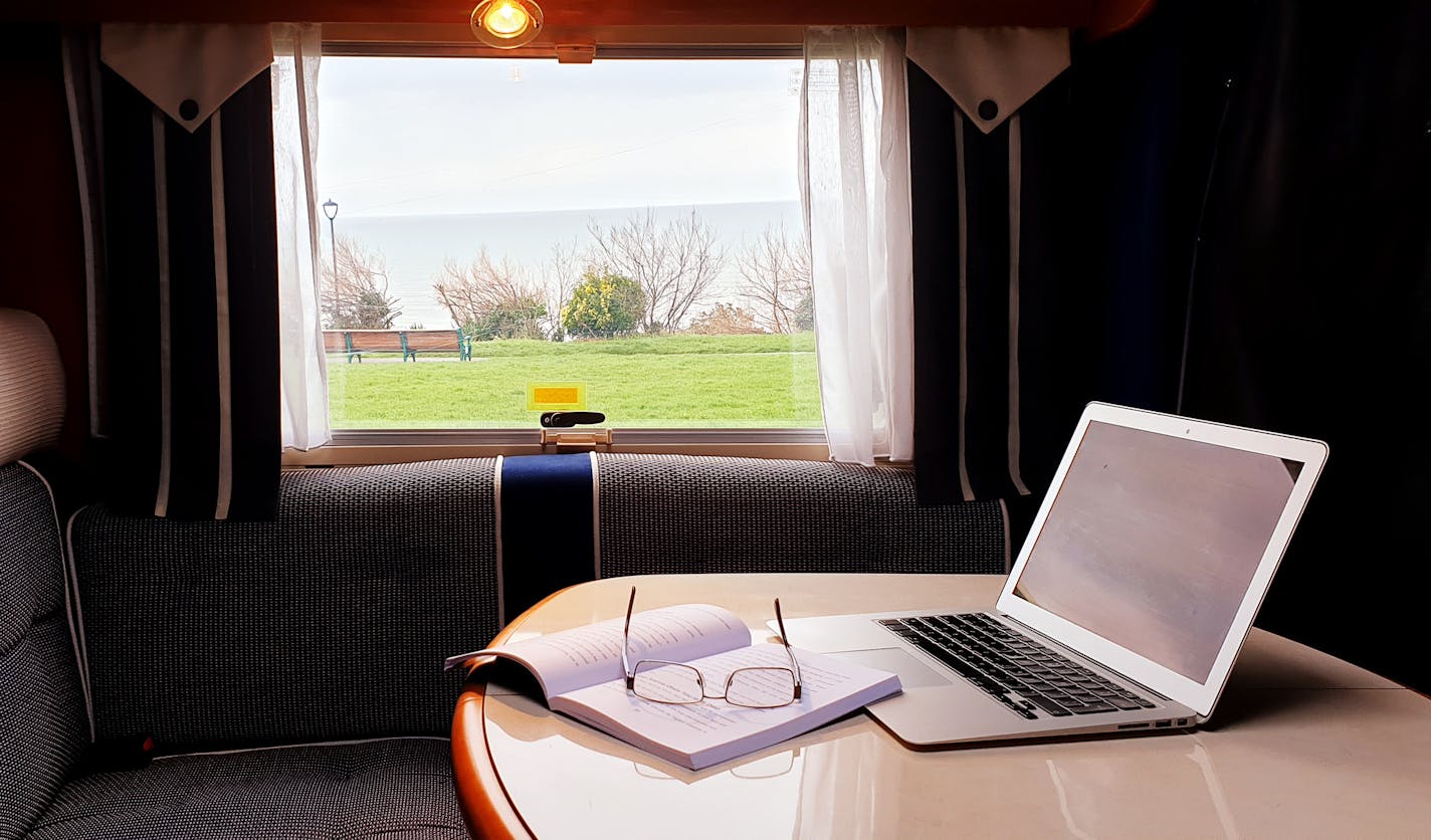 Living and working off-grid in a motorhome. Laptop, books, sea view