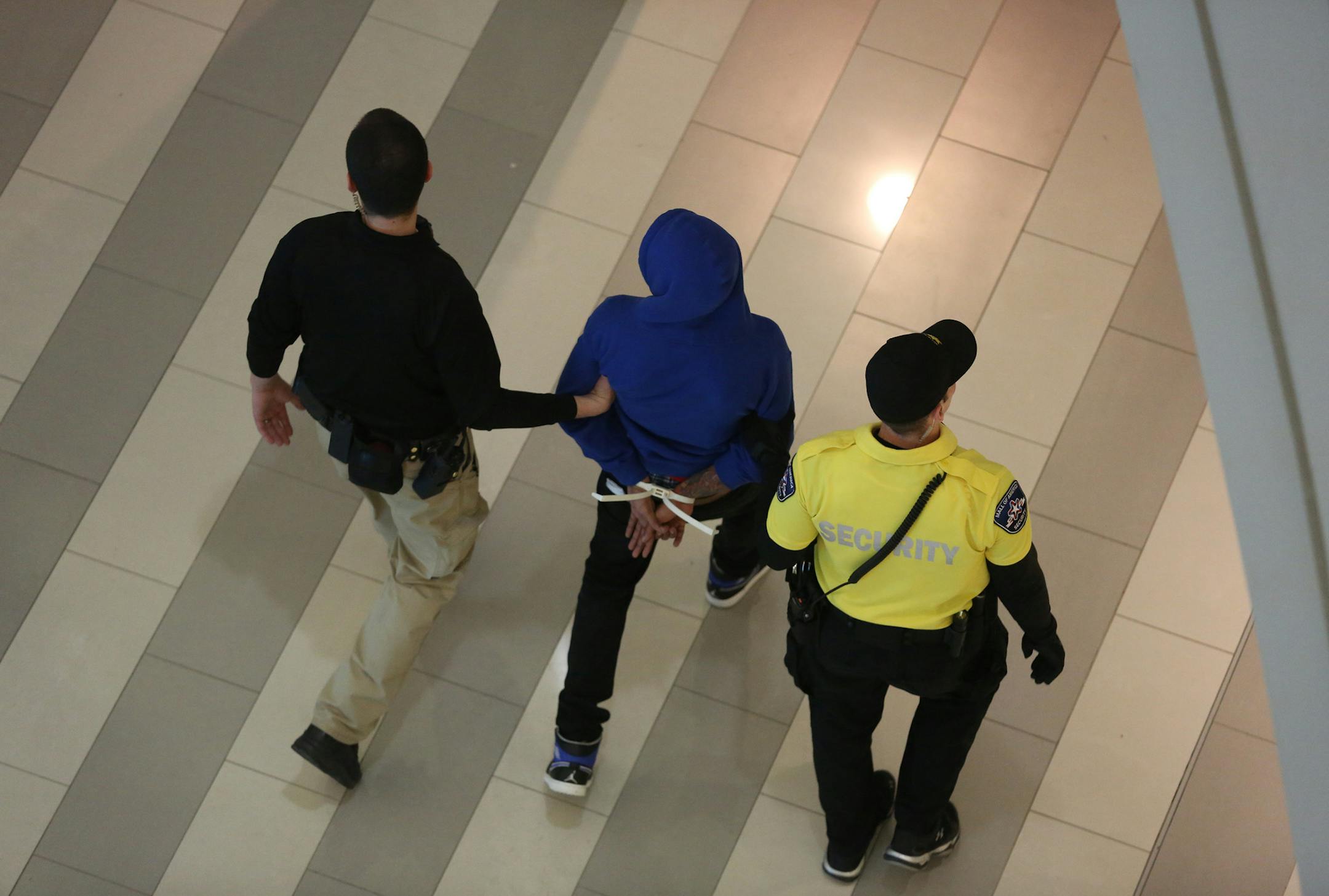 Protester was led away near the rotunda. ] (KYNDELL HARKNESS/STAR TRIBUNE) kyndell.harkness@startribune.com Protest at MOA in Bloomington Min., Saturday, December 20, 2014.