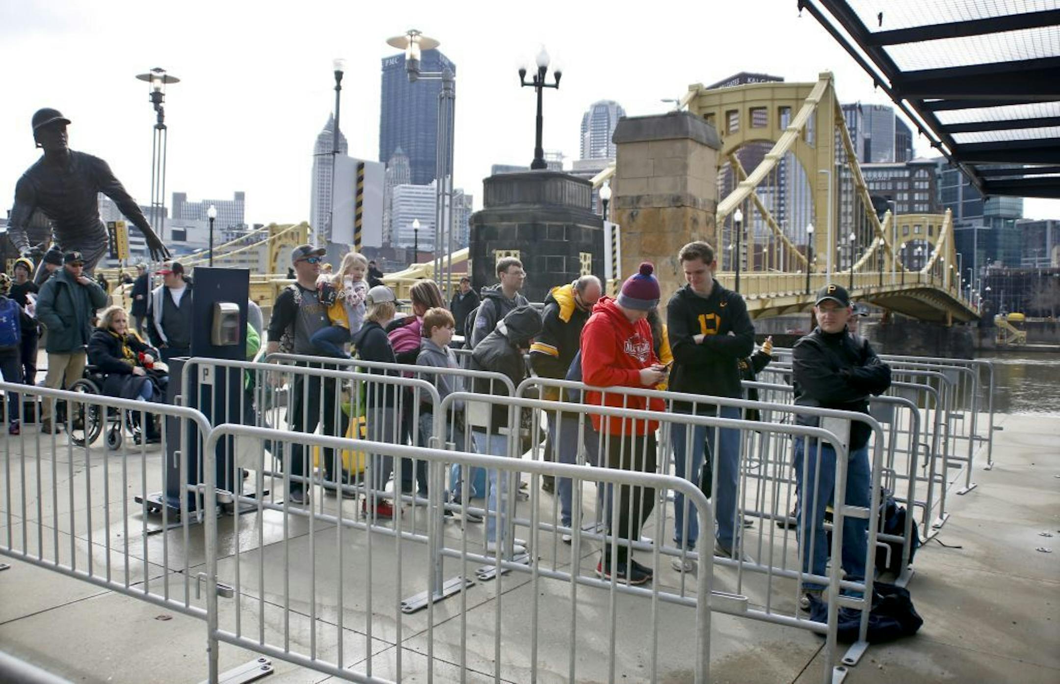 Fans wait outside the right field gates under the Roberto Clemente statue before the Pirates' home opener baseball game against the Minnesota Twins , Monday, April 2, 2018, in Pittsburgh.