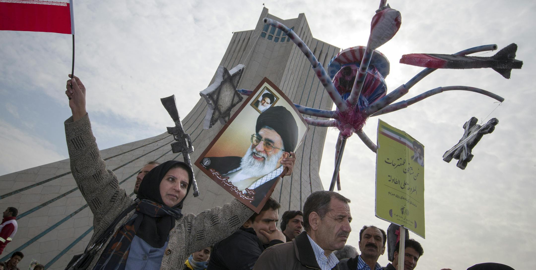 An Iranian woman raises a poster of Iran's Supreme Leader Ayatollah Ali Khamenei during a rally to mark the 35th anniversary of the Islamic revolution, in Tehran, Iran, Feb. 11, 2014. Millions of Iranians participated in the government-backed rallies, Iranian state media reported, focusing on the ongoing nuclear talks between Iran and world powers while celebrating a victory that brought government power to Shiite Muslim clerics. (Morteza Nikoubazl/The New York Times)