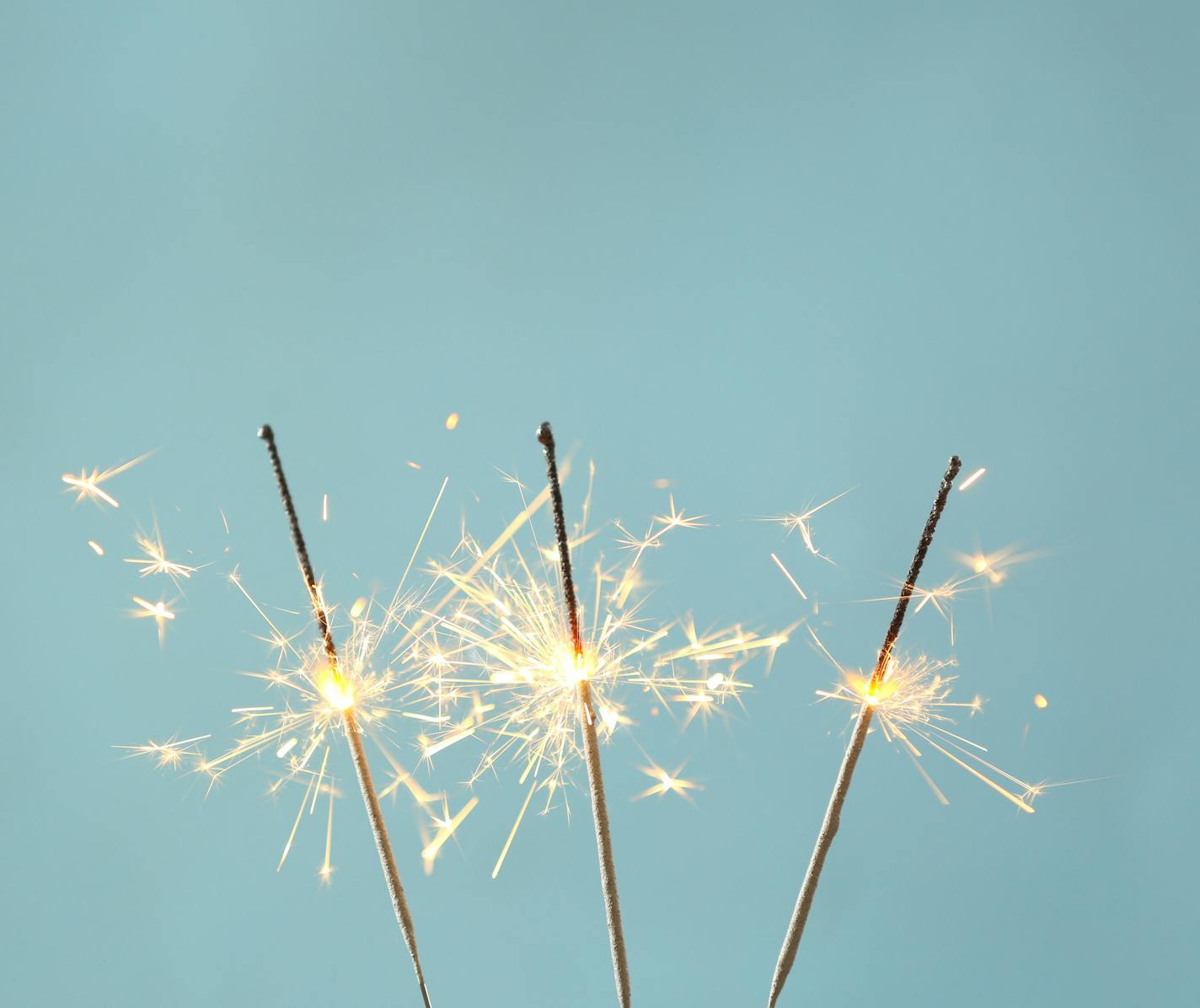 Festive sparklers on color background