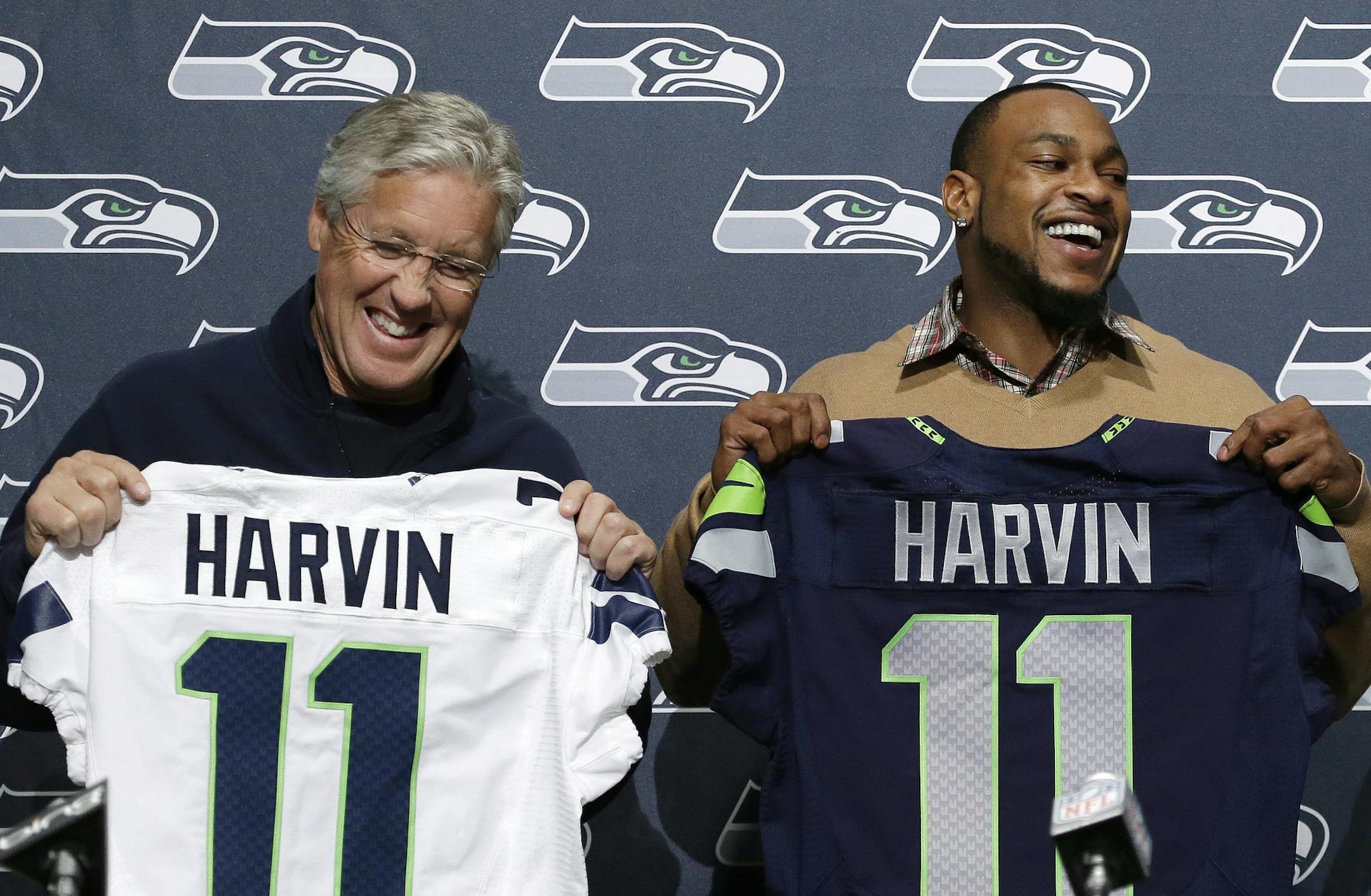 Seattle Seahawks' Percy Harvin, right, and coach Pete Carroll hold jerseys before a news conference at the NFL football team's headquarters Tuesday, March 12, 2013, in Renton, Wash. The Seahawks completed their trade with Minnesota to acquire the wide receiver in exchange for a trio of draft picks. The 24-year-old Harvin will give second-year quarterback Russell Wilson a dynamic playmaker not yet at his peak and reunite him with former teammate Sidney Rice and former offensive coordinator Darrel
