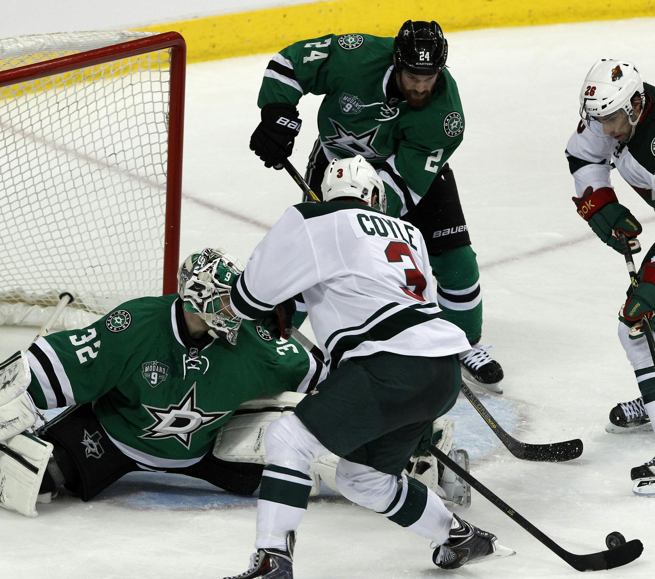 Dallas Stars goalie Kari Lehtonen (32) defends as Minnesota Wild center Charlie Coyle (3) goes to take a shot during the second period of an NHL hockey game in Dallas on Saturday, March 8, 2014.(AP Photo/ Richard W. Rodriguez)