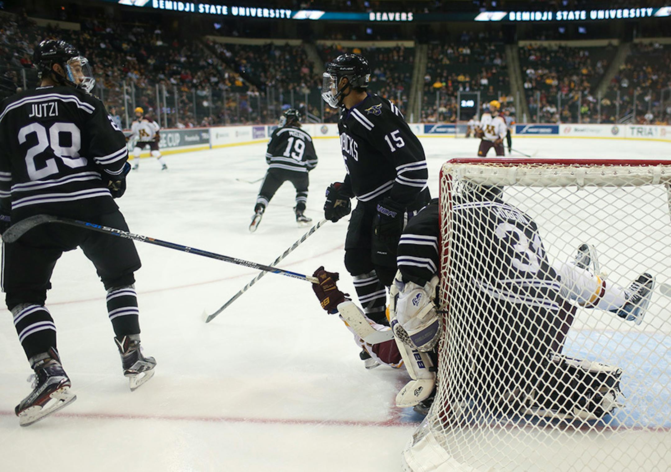 Gophers forward Hudson Fasching (24) was detained in the crease by Mavericks forward C.J. Franklin (15) and Mavericks goalie Cole Huggins (34) in the third period Sunday afternoon.