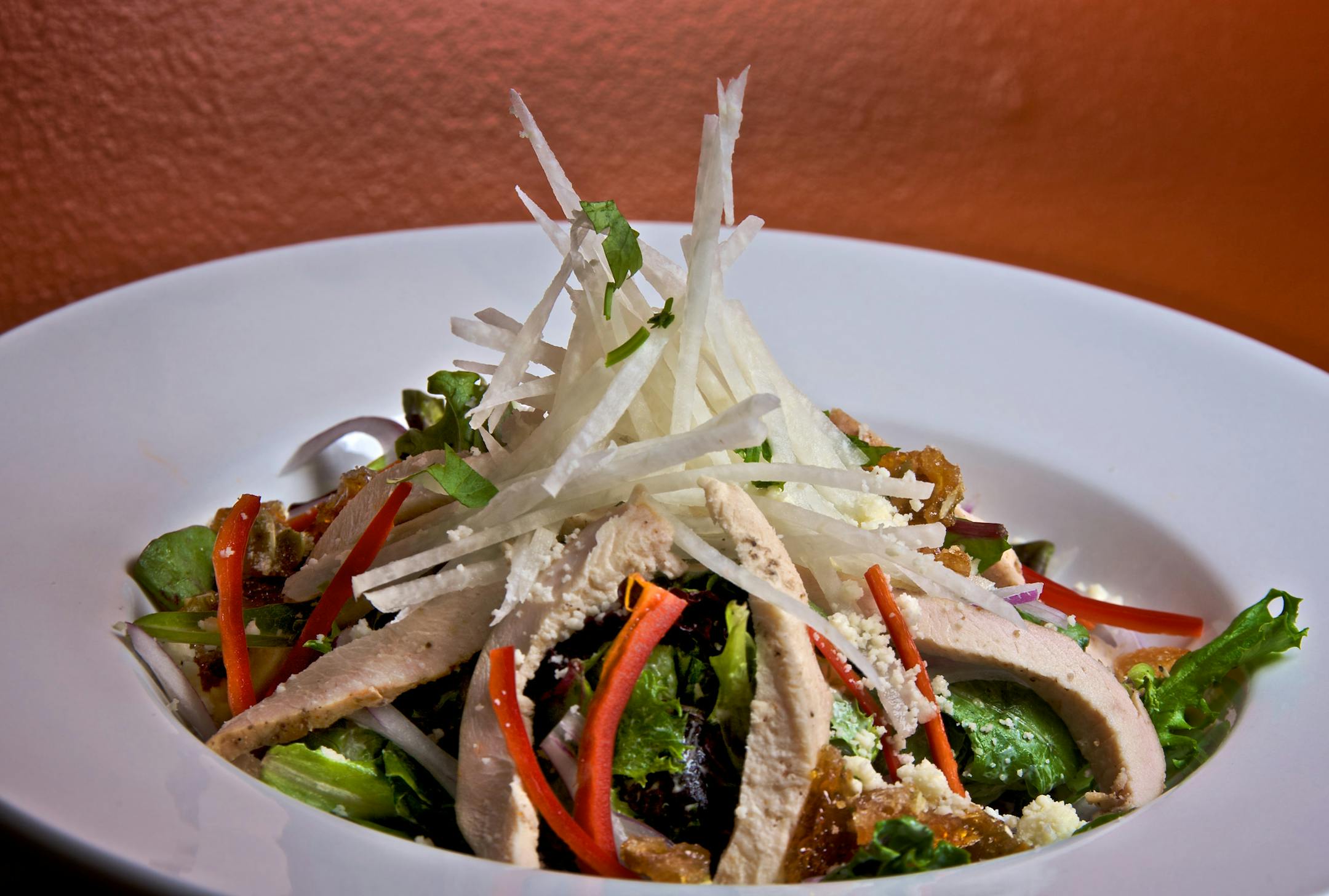 The Adobo smoked chicken and jicama salad with spring greens, red onions, with spicy pepita brittle, queso fresco and cilantro-lime dressing are offered at Senor Wong's.