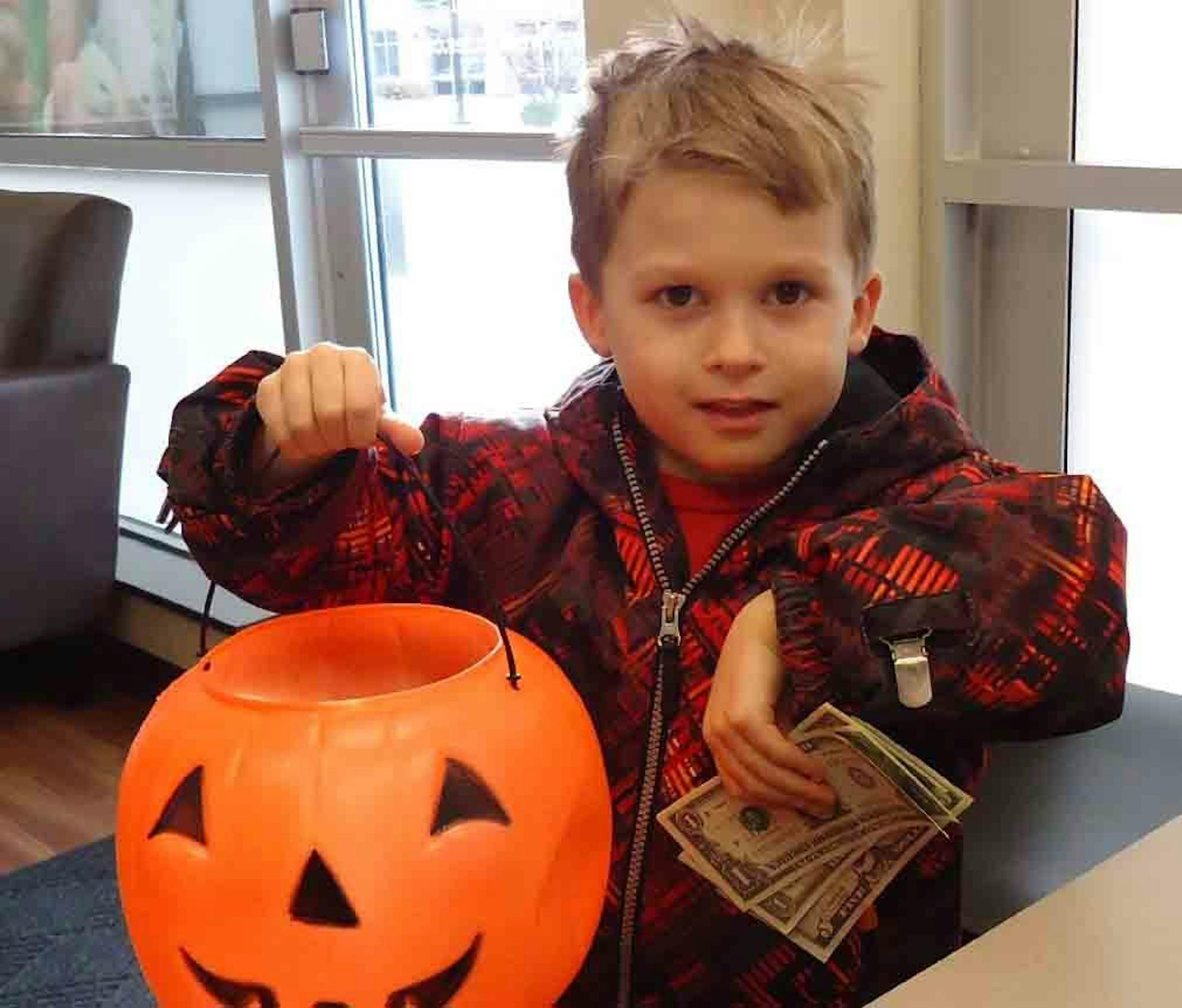 Chase Berger, of Chaska, with his empty candy bucket after he sold his extra candy last year to a Chanhassen dentist. Tori-Thuy Conrad has donated the goodies to U.S. troops and families in need every Halloween for the last four years.