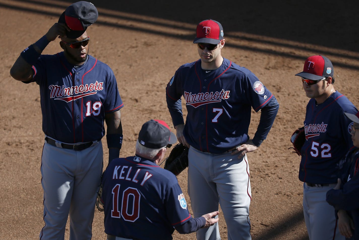 Tom Kelley spoke with first baseman Kennys Vargas, Joe Mauer and Byung Ho Park during practice on Sunday.