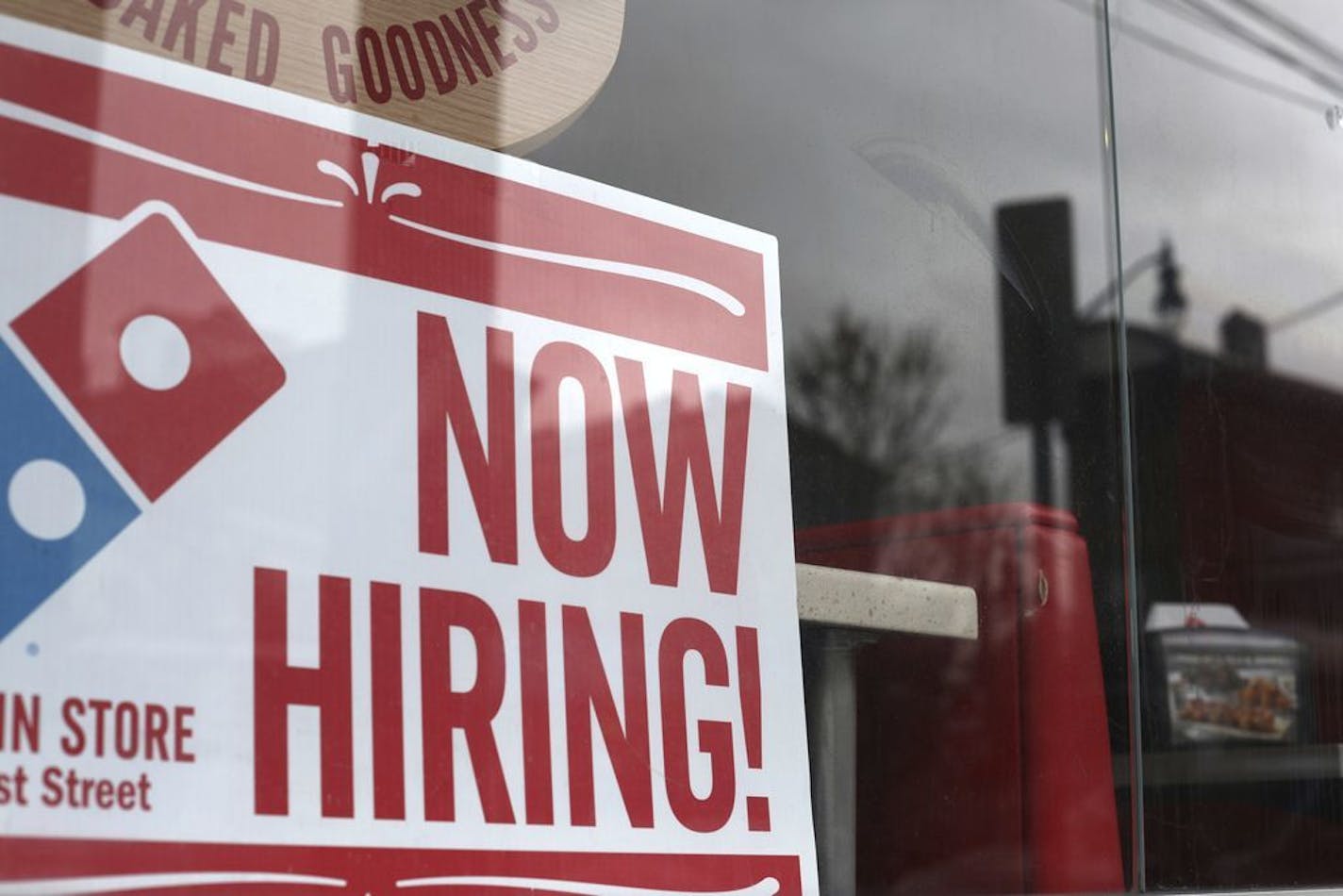 In this April 14, 2019, photo a now hiring sign is posted at a Domino's Pizza in Jersey City, N.J.