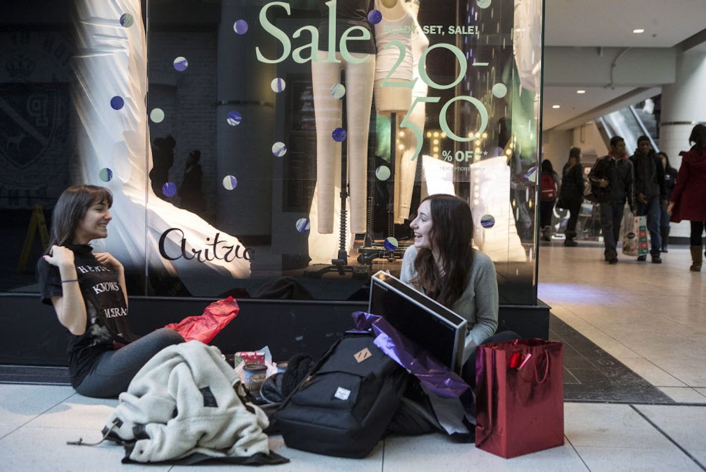 Shoppers compare purchases after an early visit to the Boxing Day Sales at the Eaton Centre in downtown Toronto on Thursday, Dec. 26, 2013. Boxing Day, observed in Canada, the United Kingdom, and other Commonwealth nations on the day after Christmas, is primarily known as a shopping holiday, much like Black Friday in the United States. (AP Photo/The Canadian Press, Chris Young)