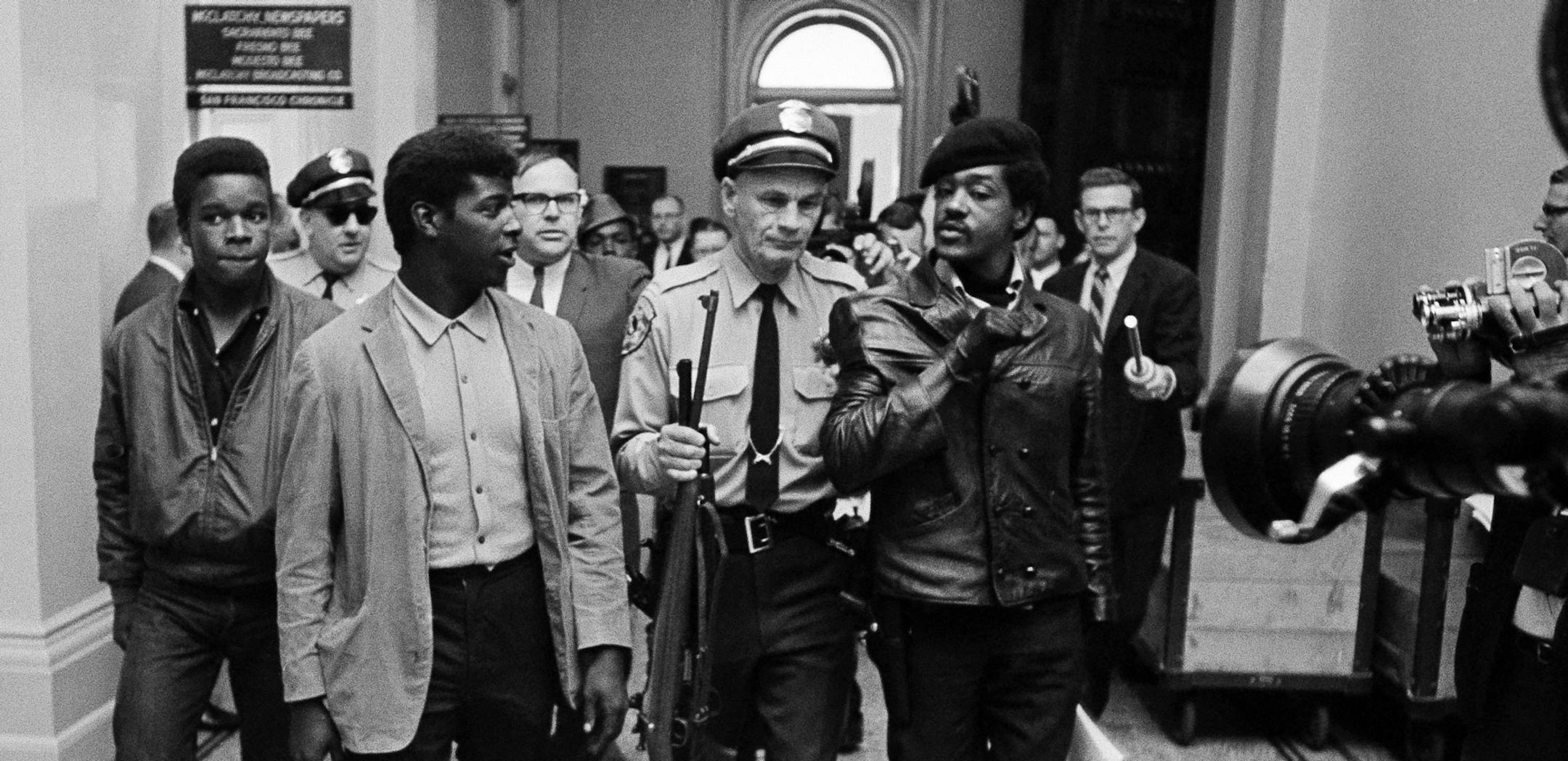 A California State Policeman escorts members of the Black Panther Party down the corridor of the Capitol in Sacramento, California, May 2, 1967. The armed Panther said they were protesting a bill before the Legislature restricting the carrying of arms in public. (AP Photo ) ORG XMIT: APHS81330