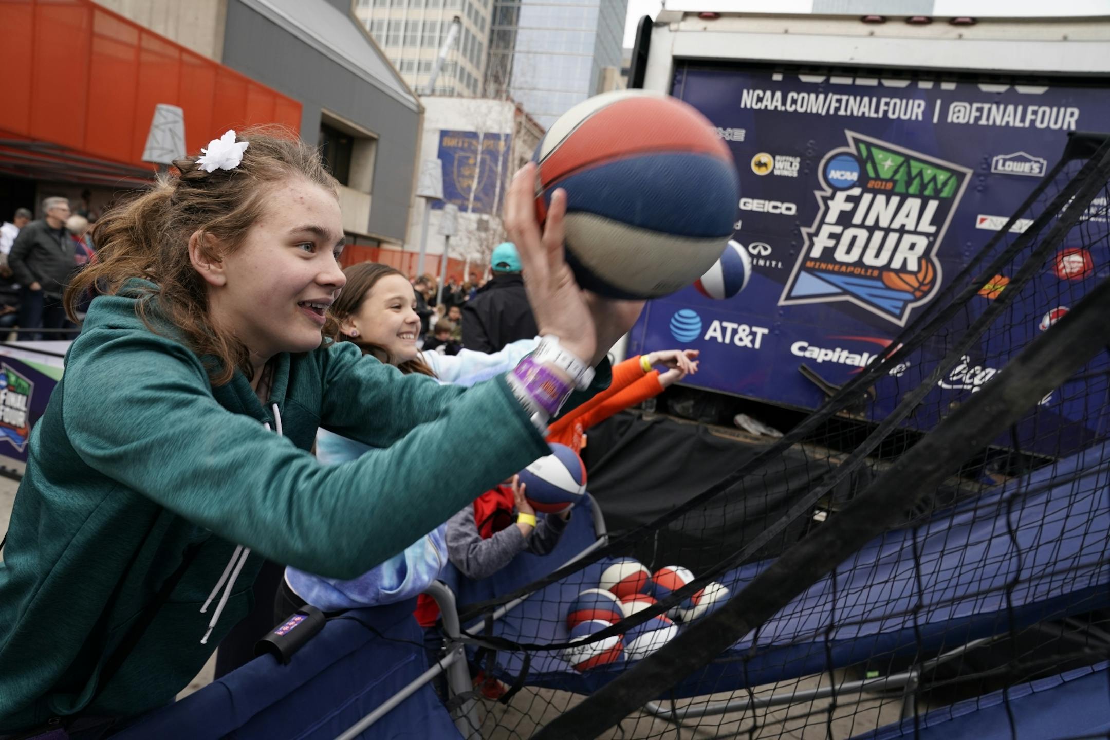 Lily Larson, 14, from left, shoots hoops with friend Brooklyn Erickson, 11, both of Minneapolis, at the Tip-Off Tailgate on Nicollet Mall.