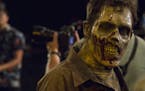 A zombie walks around and interacts with the media during a zombie bootcamp led by Greg Nicotero, co-executive producer and director of "The Walking D