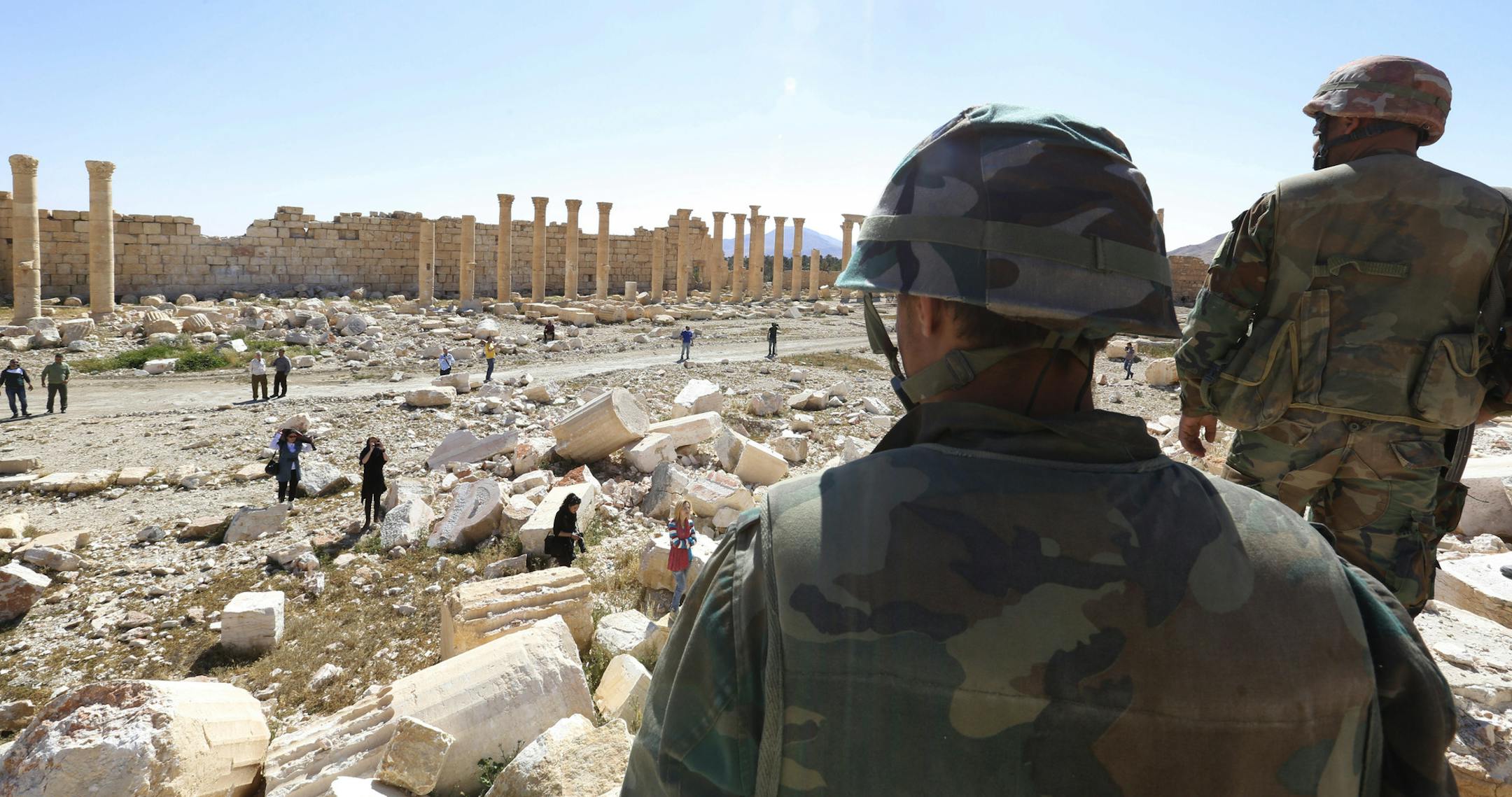 In this picture taken Friday, April 1, 2016, soldiers look over damage at the historical Bel Temple in the ancient city of Palmyra in the central city of Homs, Syria. Explosions rocked the ancient town of Palmyra on Friday and on the horizon, black smoke wafted behind its majestic Roman ruins, as Syrian army experts carefully detonated hundreds of mines they say were planted by Islamic State militants before they fled the town. (AP Photo)