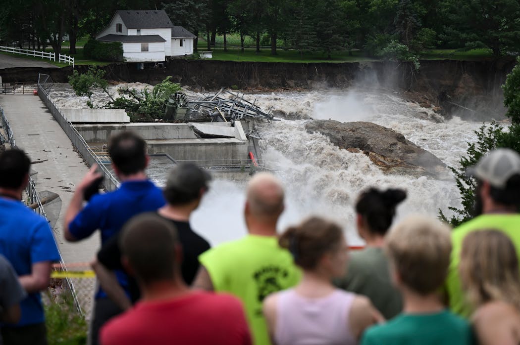 A home teeters on the brink of collapsing into the Blue Earth River near the Rapidan Dam in Mankato on Monday.