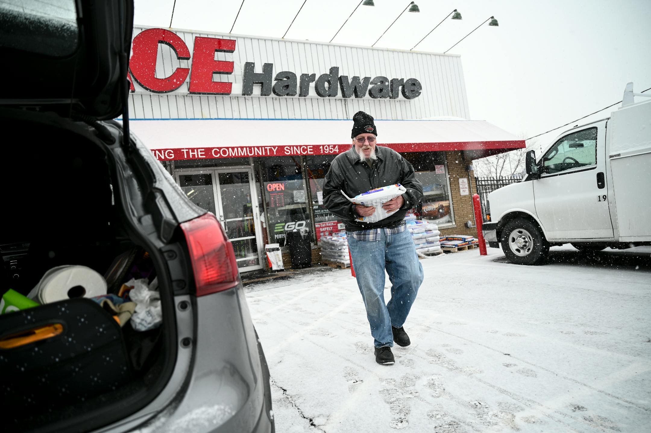 Kit Quigley, of Robbinsdale, carries a bag of ice melt to his SUV Tuesday, outside Welna's Ace Hardware in Robbinsdale. "I'm tired of snow," said Quigley. We've had way too much this year."
