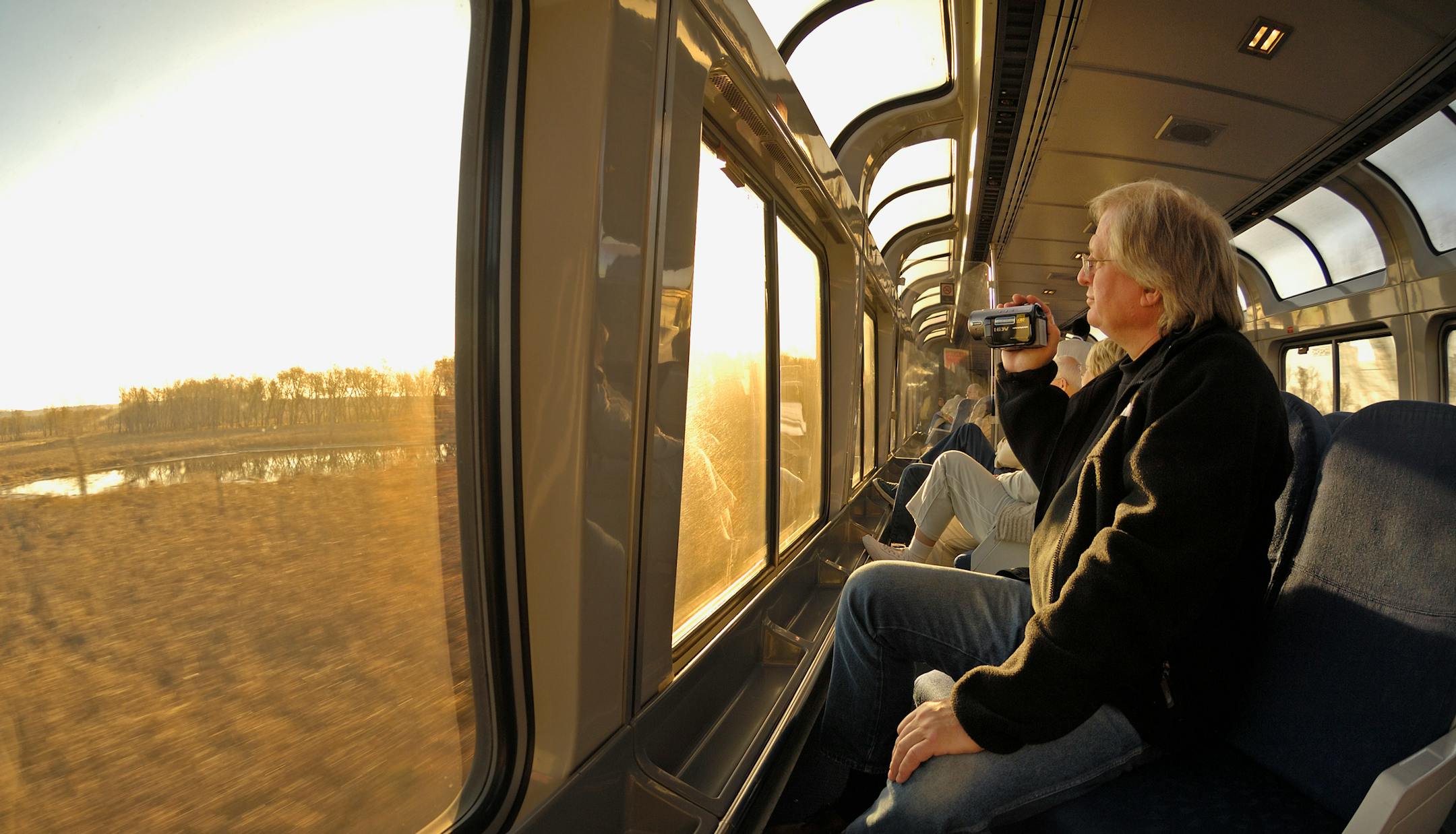 In the lounge car (where you can buy a cup of coffee and snacks), John Stopa (from Chicago, but grew up in Minneapolis) takes videos of the passing scenery at sunrise just outside Hastings, MN.