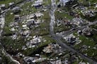 FILE - In this Thursday, Sept. 28, 2017 file photo, destroyed communities are seen in the aftermath of Hurricane Maria in Toa Alta, Puerto Rico. The H