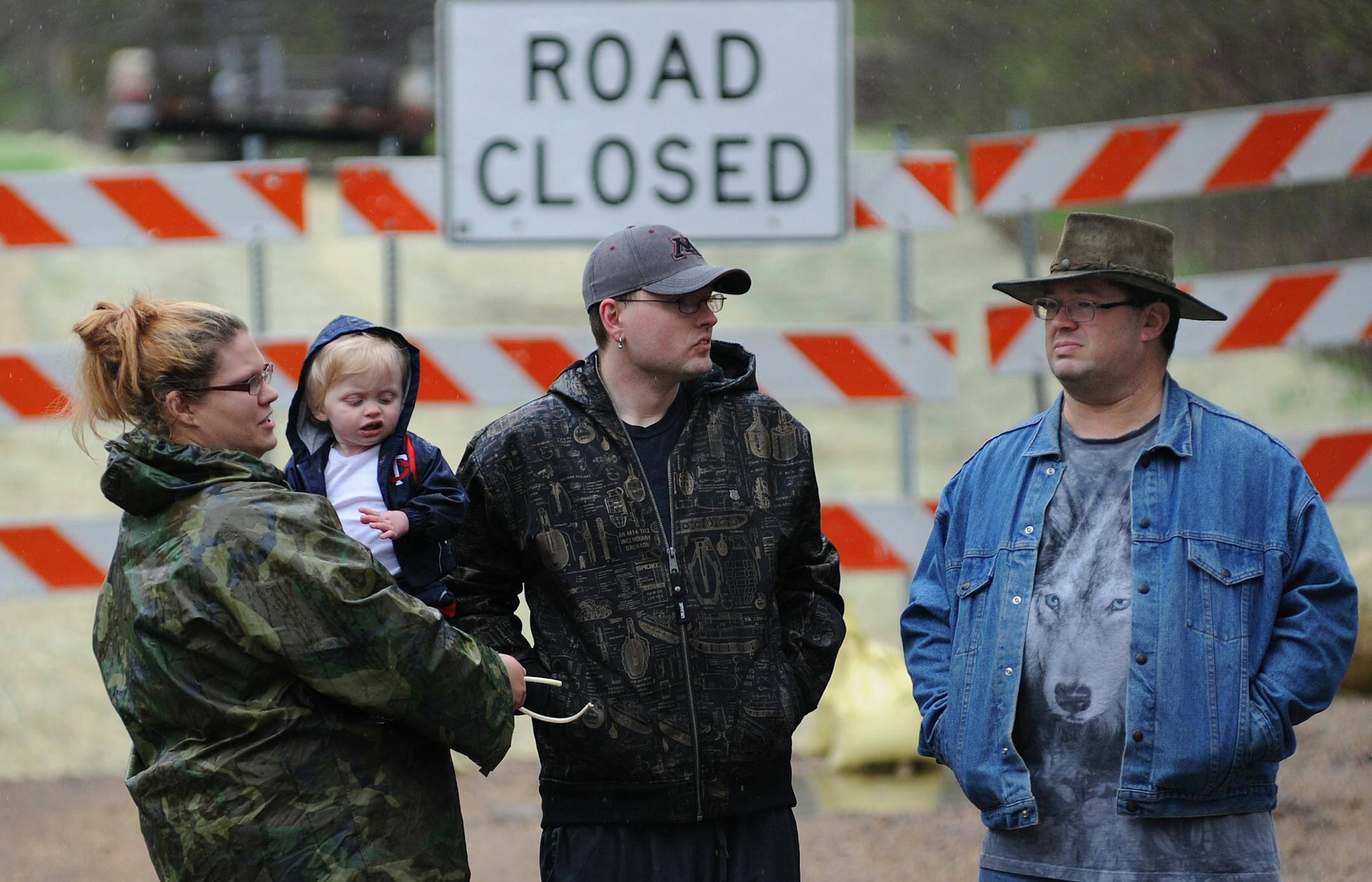 Katie Radke, holding her 14-month-old son Jackson, her husband, Ian Brown, and Douglas Van Dyke, right, are among the Oak Park Heights residents affected by the closure of Peabody Road by the state Department of Transportation because of construction on the St. Croix River bridge project.