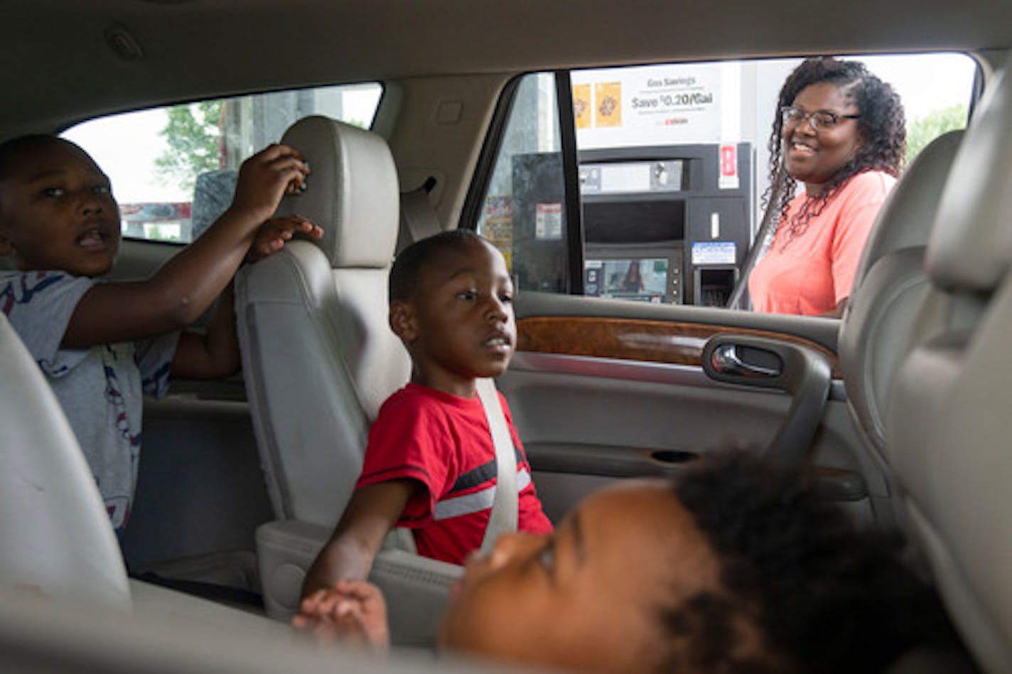 Jessica Loveless pumped gas into her vehicle while her sons Zyaire, 5, Zion, 7, and Zakari, 1 left to right, waited Wednesday at a Speedway gas station in Hastings. Gas prices in Hastings are lower than the rest of the state.