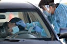 In this June 27, 2020, photo, people are tested in their in vehicles in Phoenix's western neighborhood of Maryvale in Phoenix for free COVID-19 tests 
