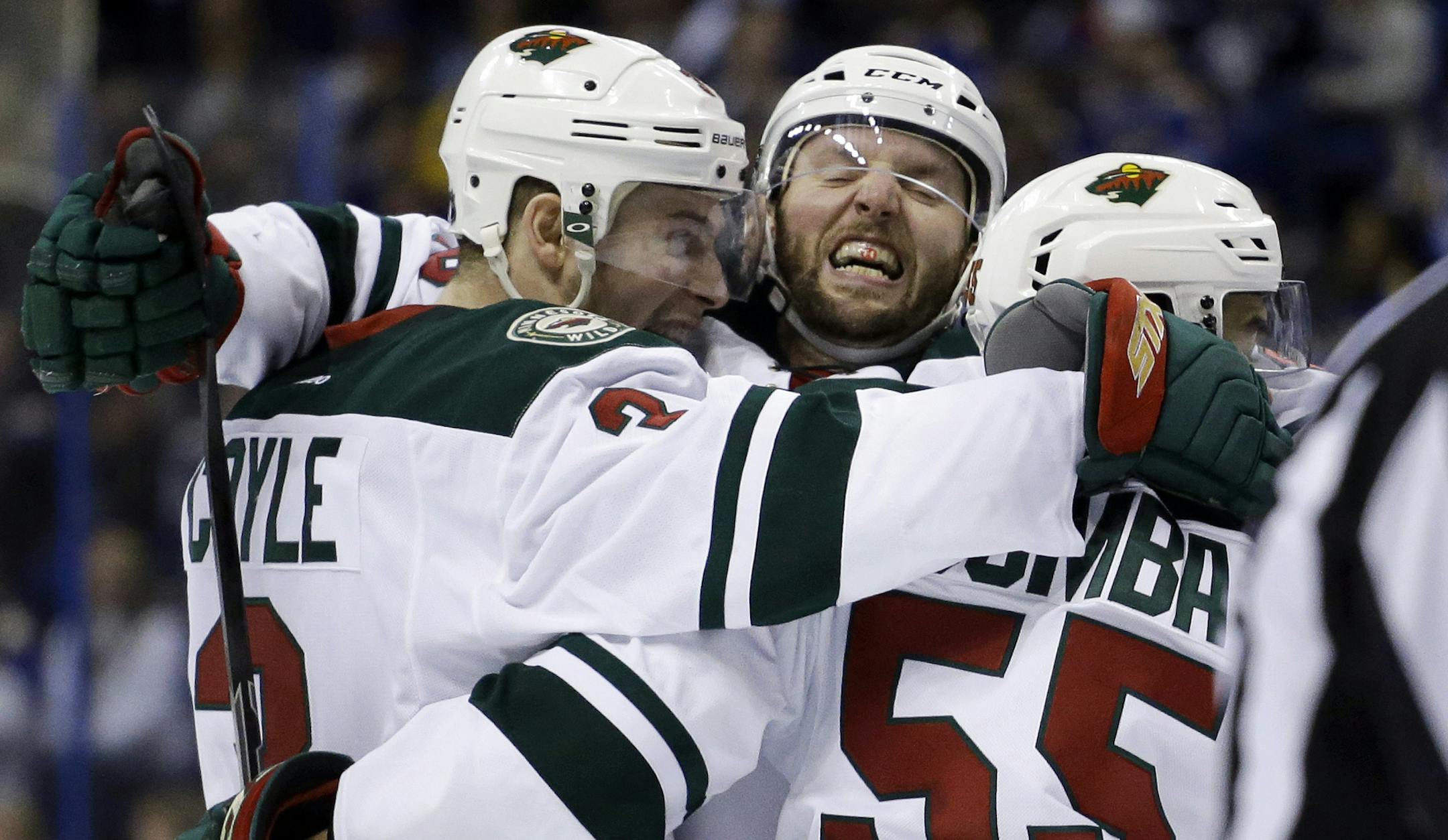 Minnesota Wild's Charlie Coyle, left, is congratulated by teammates Thomas Vanek, of Austria, and Matt Dumba, right, after scoring during the third period in Game 5 of an NHL hockey first-round playoff series against the St. Louis Blues, Friday, April 24, 2015, in St. Louis. The Wild won 4-1. (AP Photo/Jeff Roberson)