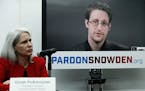 Dinah PoKempner, left, general council for Human Rights Watch, listens as Edward Snowden speaks on a television screen via video link from Moscow duri