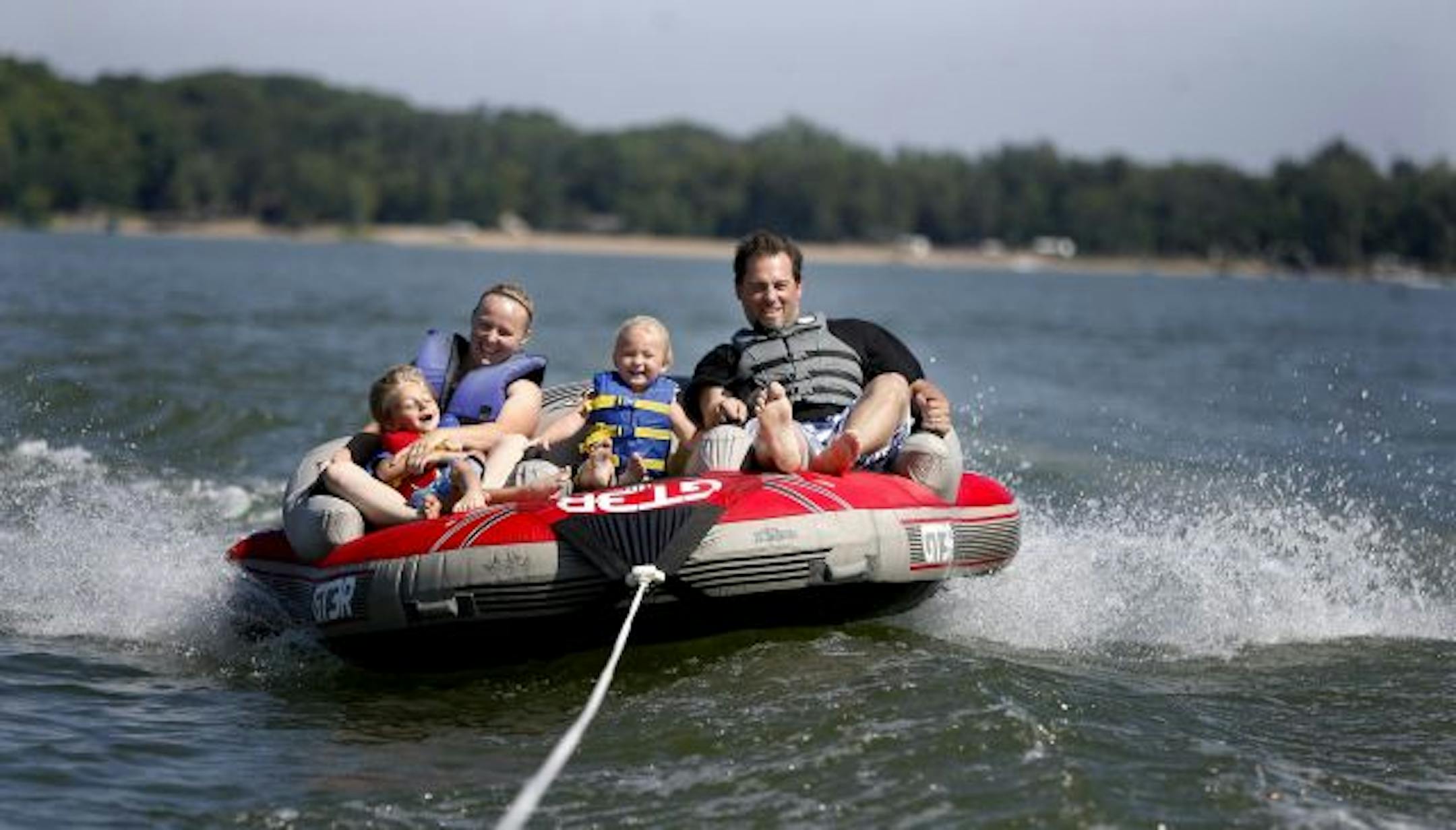 The Stover family of Ramsey – from left, Nicole, Logan, 6, who has cerebral palsy, Maisie, 3, and Greg — held on tight during a tube ride last week at Camp Courage in Maple Lake, Minn. Camp Courage holds four summer camps for more than 50 families.