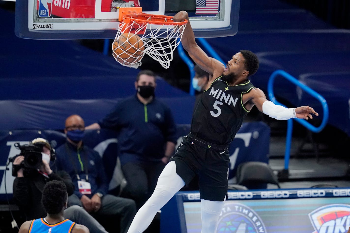 Minnesota Timberwolves guard Malik Beasley (5) dunks in front of Oklahoma City Thunder guard Hamidou Diallo, left, in the first half of an NBA basketball game Friday, Feb. 5, 2021, in Oklahoma City. (AP Photo/Sue Ogrocki)