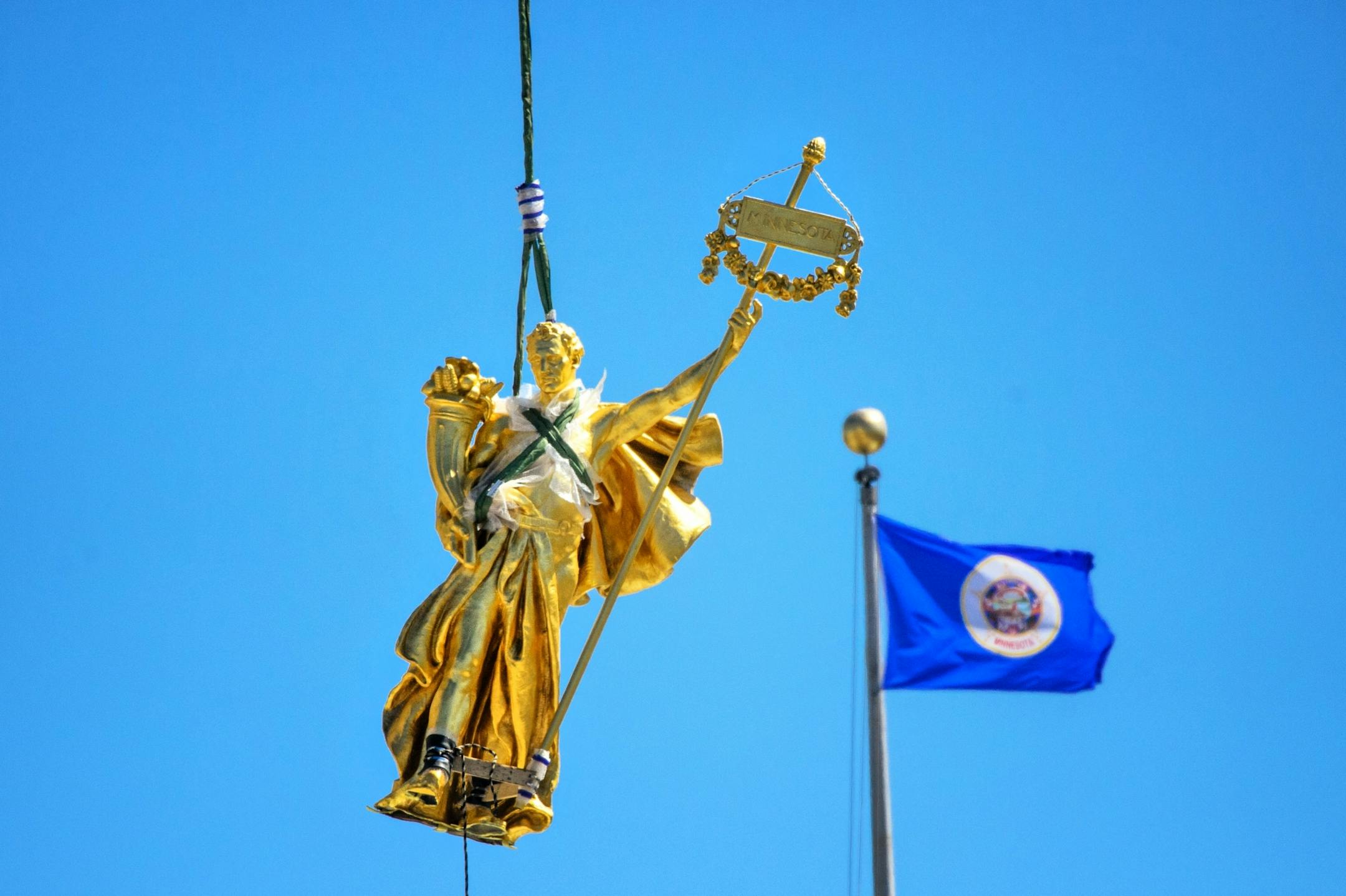 The charioteer figure, Prosperity, who guides the golden horses on the Minnesota State Capitol building's Quadriga statue returned to his home atop the building on Wednesday, April 22