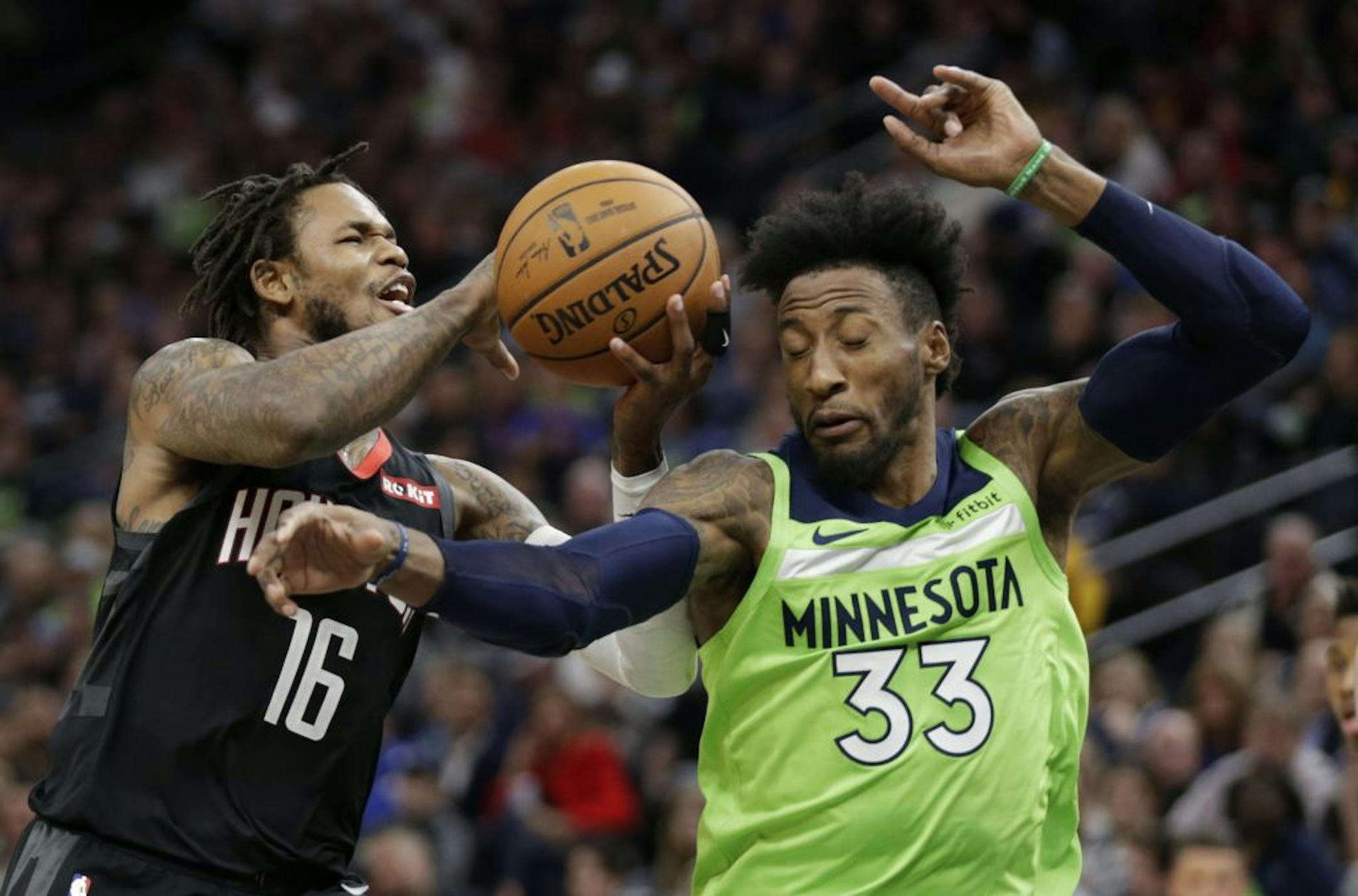Minnesota Timberwolves Robert Covington (33) tries to stop Houston Rockets forward Ben McLemore (16) in the fourth quarter during an NBA basketball game Saturday, Nov. 16, 2019 in Minneapolis. The Rockets defeated the Timberwolves 125-105.