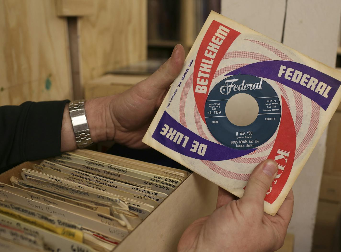 Rob Sheeley with a box of old store stock James Brown 45s, all in their original sleeves, that were part of the trove of records he bought from the estate of a record store owner in Big Spring, Texas.