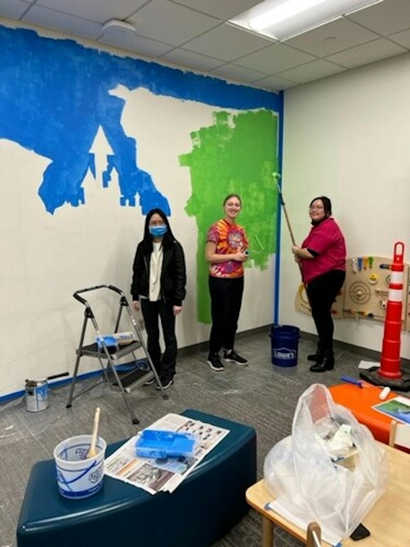 A group of Shakopee high school students painted a mural inside the children's waiting room of the Health and Human Services Department at the Scott County Government center. Recent high school graduate Kassidy Vo, current high school senior Sydney Bethel and recent high school graduate Lynda Nguyen (not pictured, recent high school graduate Lindsay Brewer and current high school senior Hayden Tran). Photo provided by Scott County and Shakopee Public Schools.