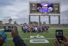 Eagan High School football players take a team photo on the field of TCO Stadium.