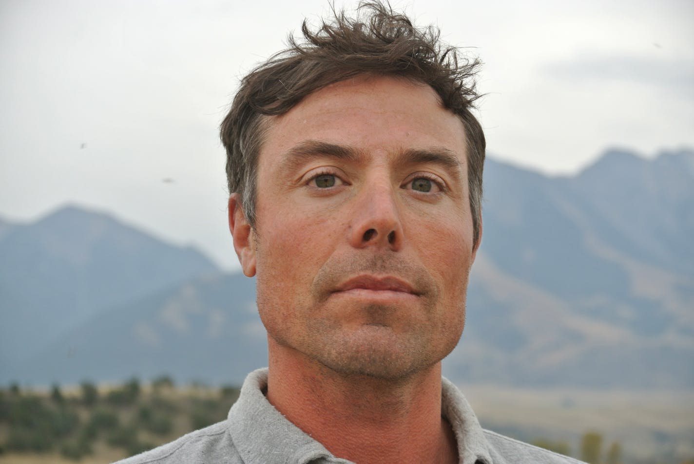 photo of author Callan Wink, with a mountain in the background