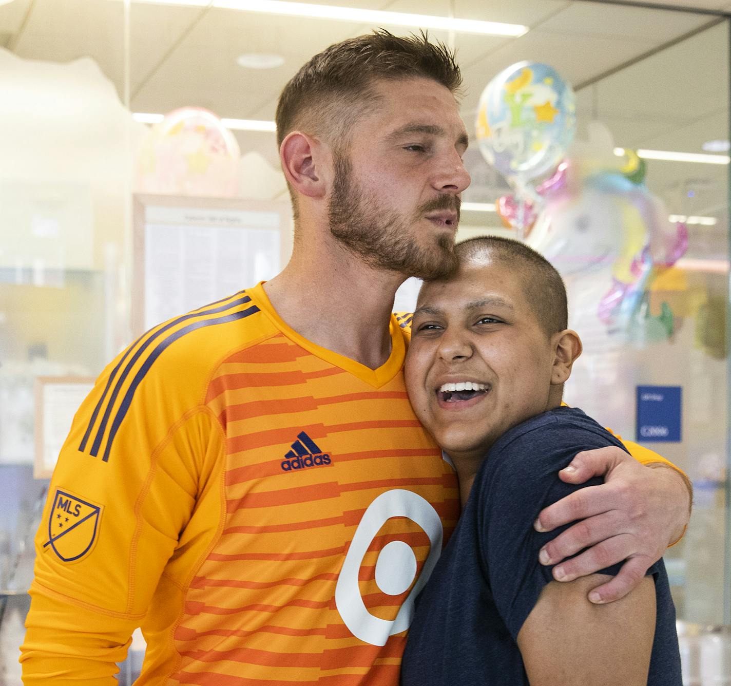 Catarina Gomez, 18, a brain cancer patient, gets a hug from Minnesota United goalkeeper Matt Lampson during his visit to the hospital. ] LEILA NAVIDI &#xef; leila.navidi@startribune.com BACKGROUND INFORMATION: Minnesota United goalkeeper Matt Lampson, who is a cancer survivor, visits children undergoing treatment at the University of Minnesota Masonic Children's Hospital in Minneapolis on Tuesday, May 22, 2018.